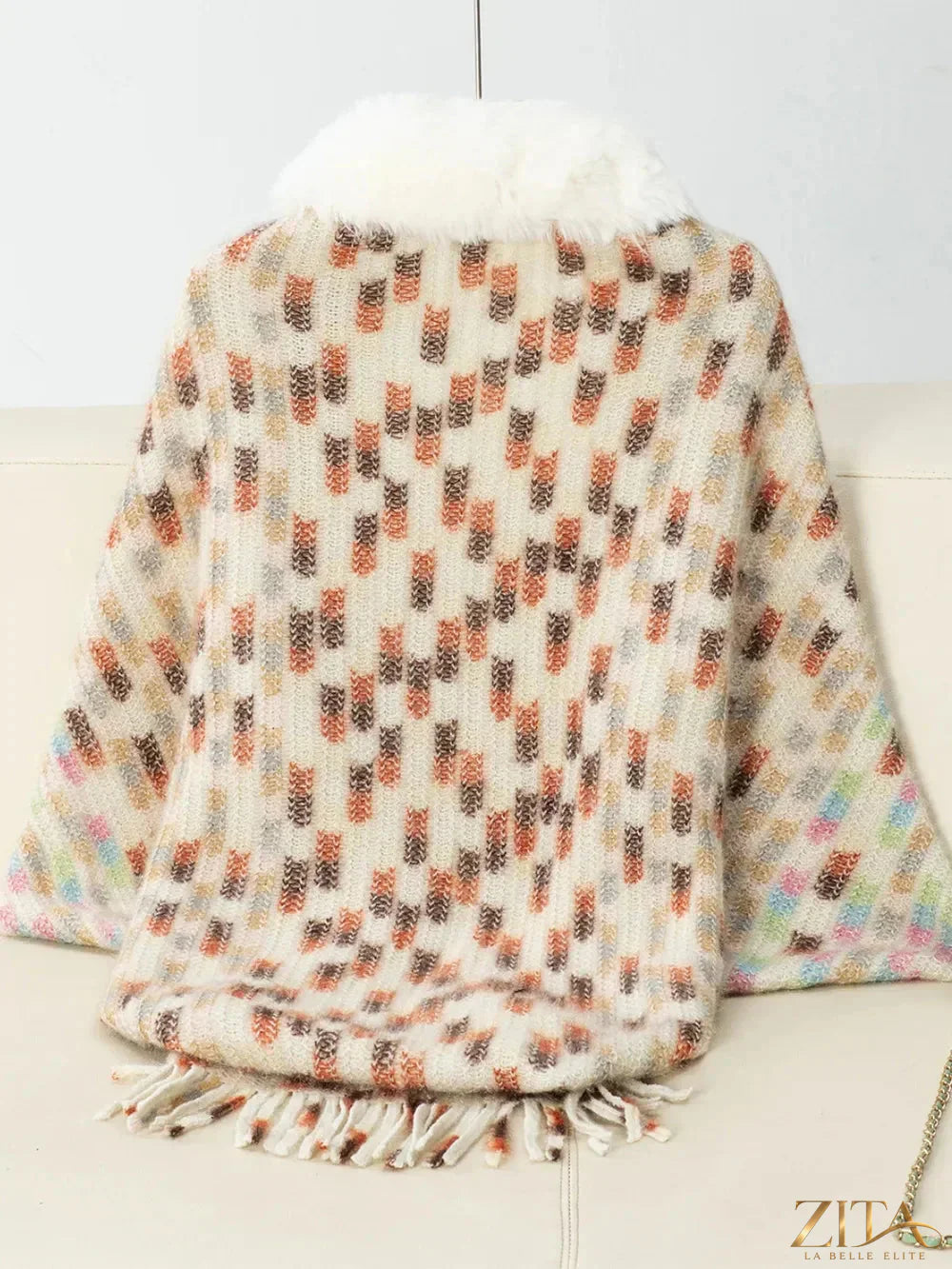 Fuzzy open front fringe poncho in soft neutral tones, featuring tassel details and a cozy, stylish fit from Trendsi.