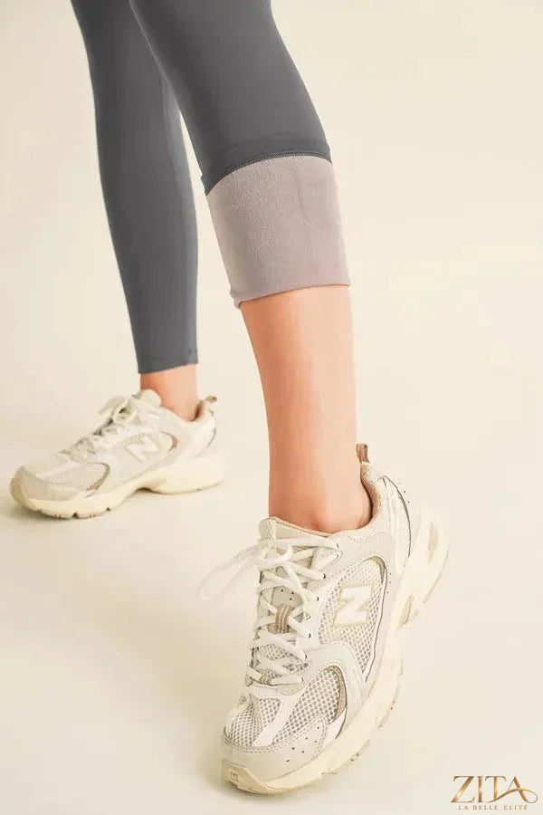 Yelete high waisted fleece-lined leggings in black, showing a close-up of the cozy, stretchy fabric and elastic waistband.