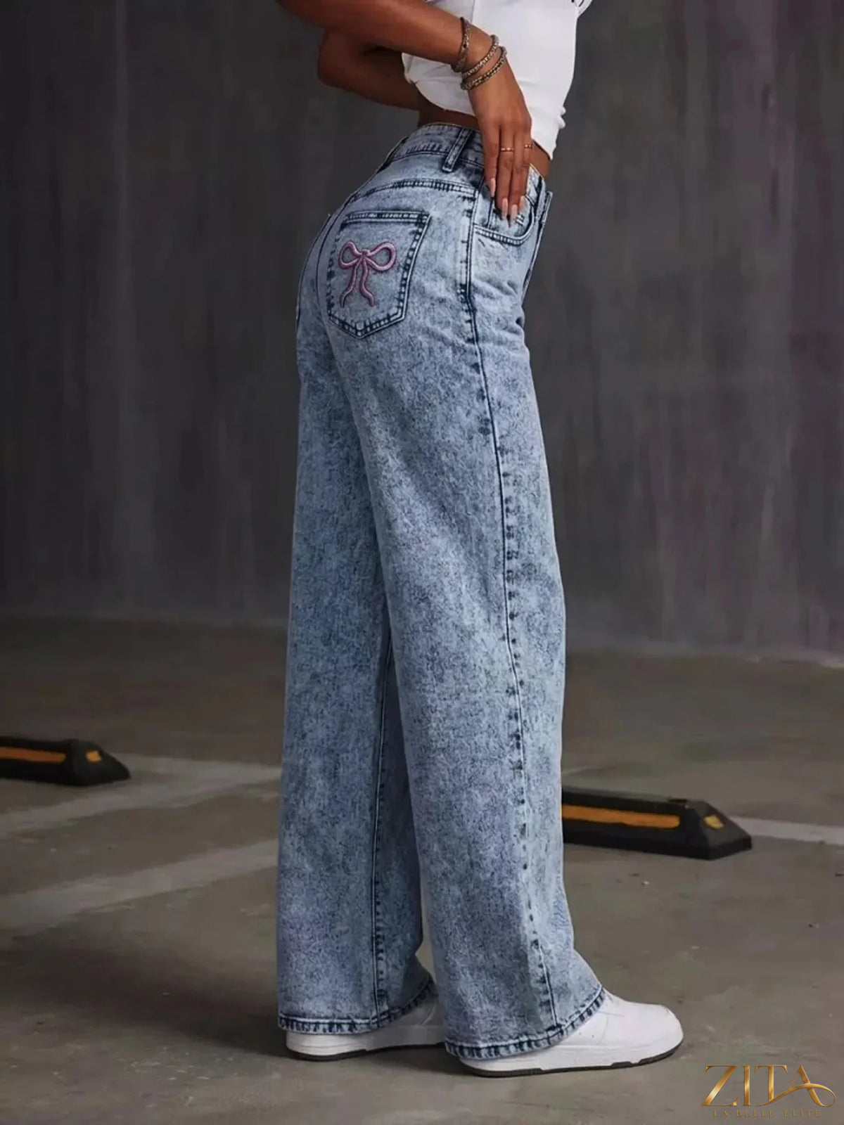 Washed wide leg jeans with embroidered bow detail from Zita La Belle Elite, featuring a relaxed fit and decorative front embroidery.