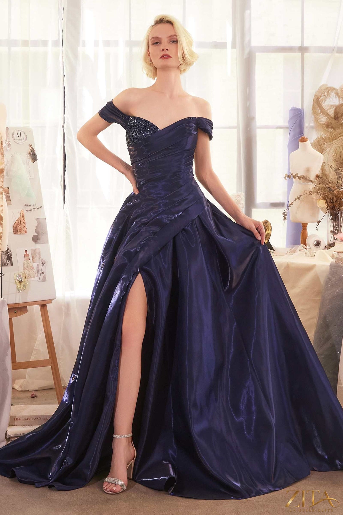 Navy off-the-shoulder organza ball gown by Zita La Belle Elite, featuring elegant ruffles and a flowing silhouette.