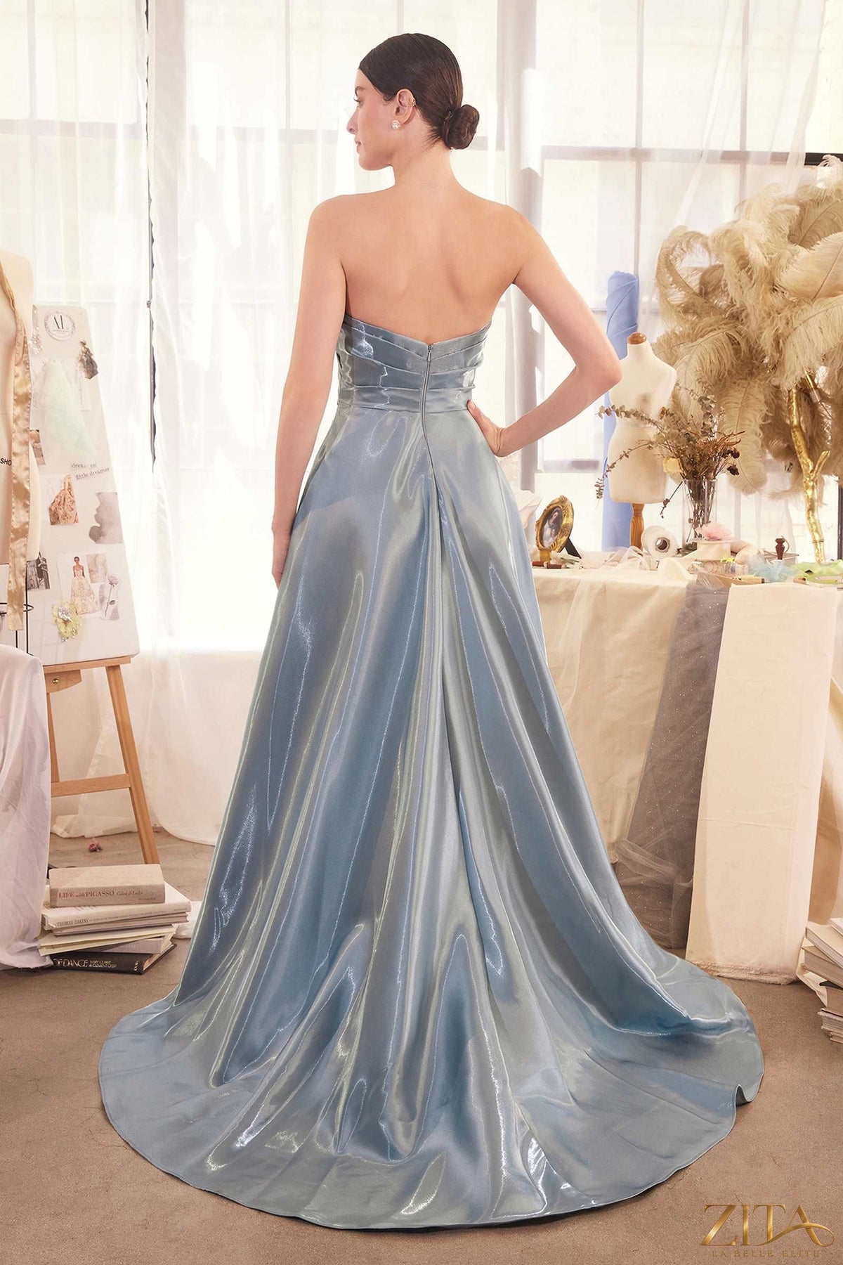Back view of Zita La Belle Elite pleated origami liquid taffeta gown in smoky blue, showcasing its elegant design and fabric texture.