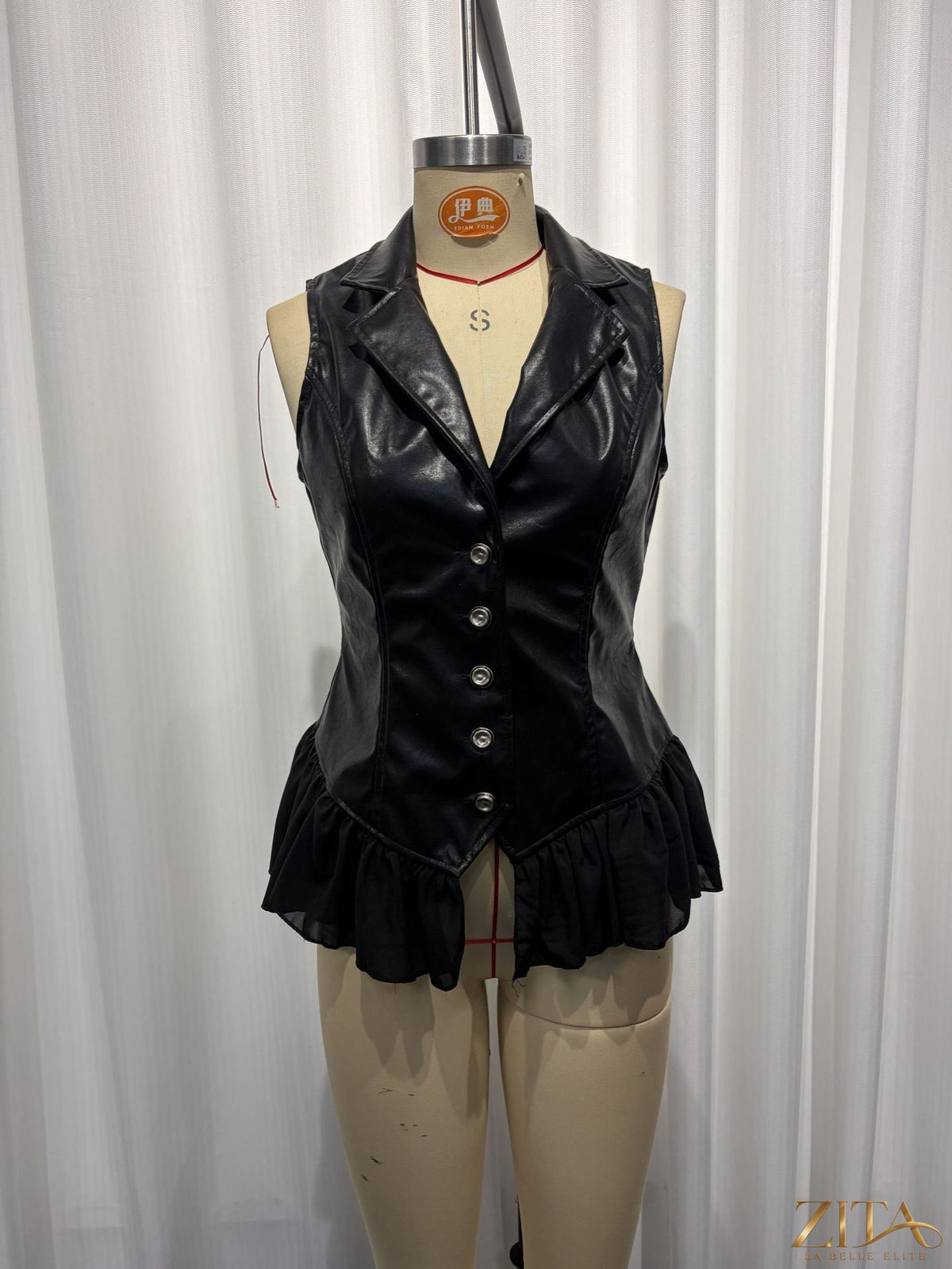 Black PU leather vest with deep V neckline, ruffle hem, fitted waist, Gothic style, by Zita La Belle Elite.