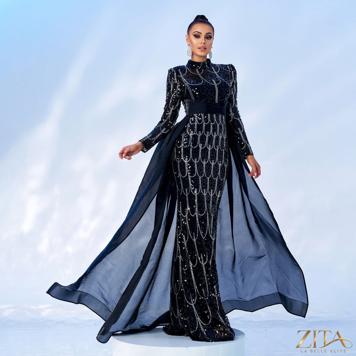 Long sleeve sequin cape fishtail evening dress by Zita La Belle Elite, featuring shimmering sequins and elegant design.