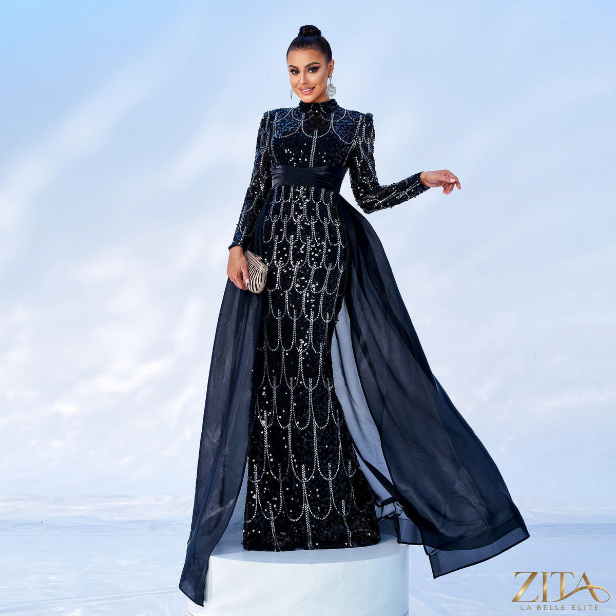 Long sleeve sequin cape fishtail evening dress by Zita La Belle Elite, featuring a shimmering sequin design and elegant silhouette.