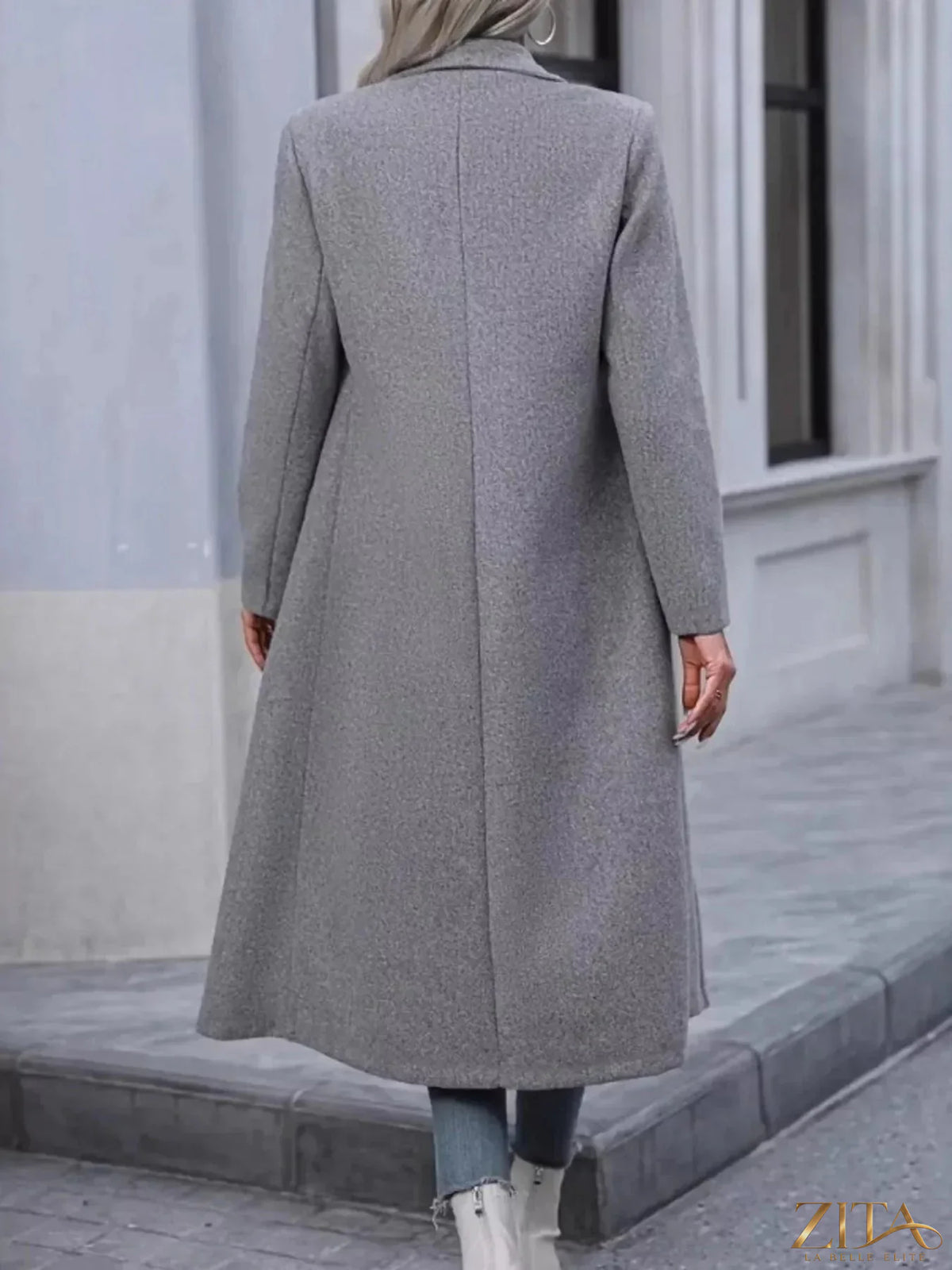 Zita La Belle Elite double-breasted longline overcoat in neutral fabric, displayed on a hanger against a plain background.