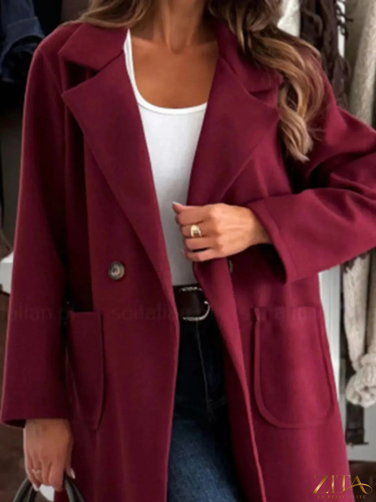 Zita La Belle Elite long-sleeve single-breasted trench coat in classic beige, displayed hanging on a wooden rack.