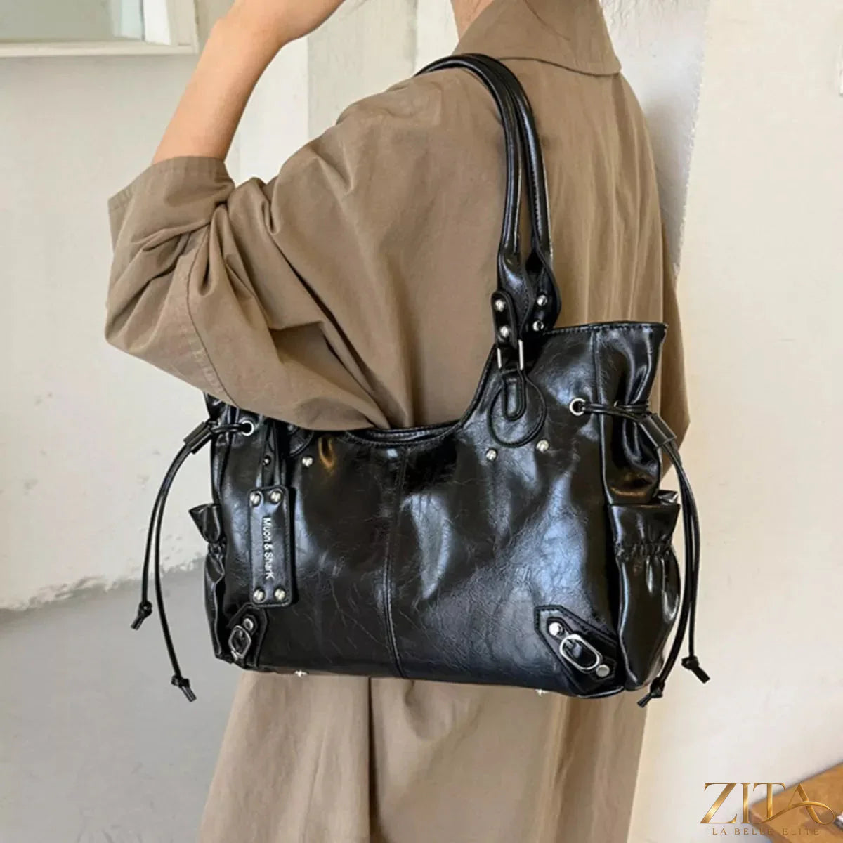 Drawstring leather handbag by Trendsi featuring a sleek design with a leather drawstring closure and stylish handles.