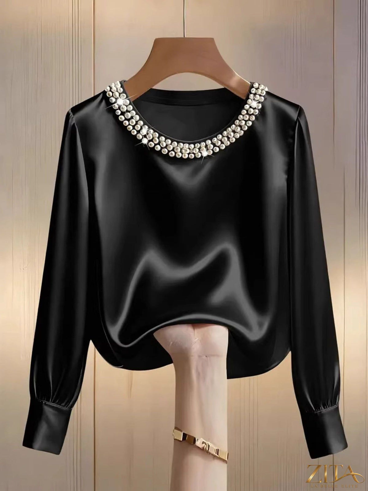 Close-up of Zita La Belle Elite silk blouse with pearl trim and round neckline, showcasing elegant fabric and detailed design.