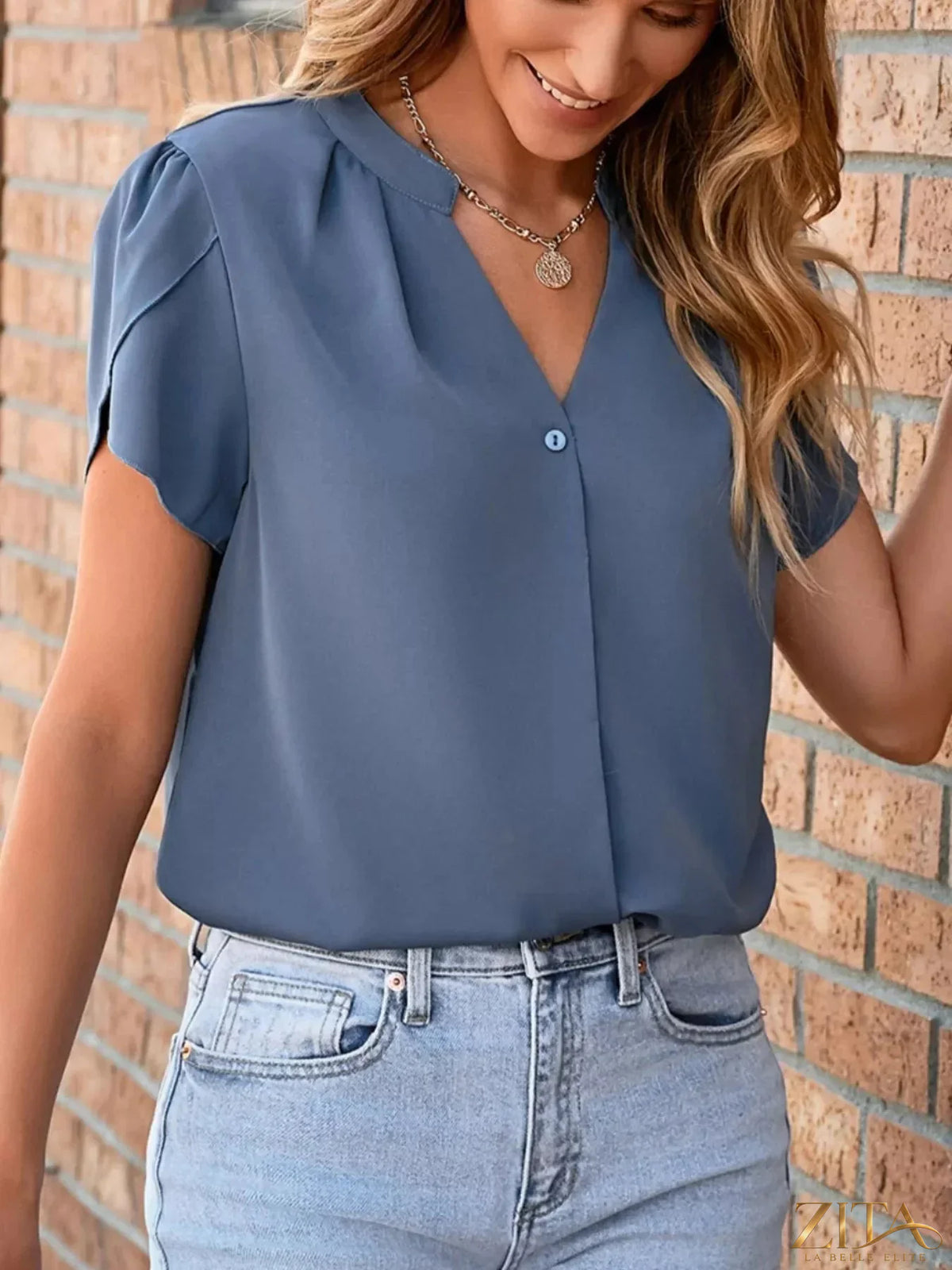 Zita La Belle Elite notched petal sleeve blouse featuring soft fabric and stylish design, displayed on a hanger.