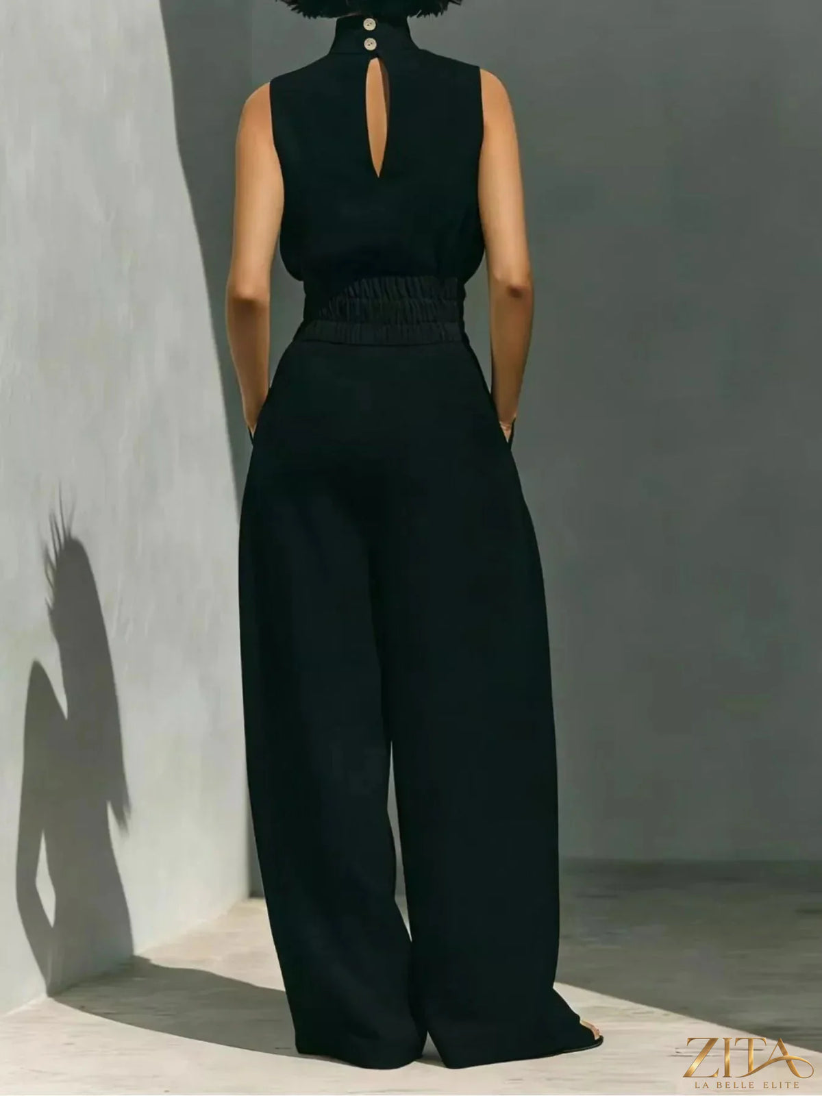Sleeveless turtleneck top and wide-leg pants set from Trendsi, featuring a sleek, modern design in neutral fabric.