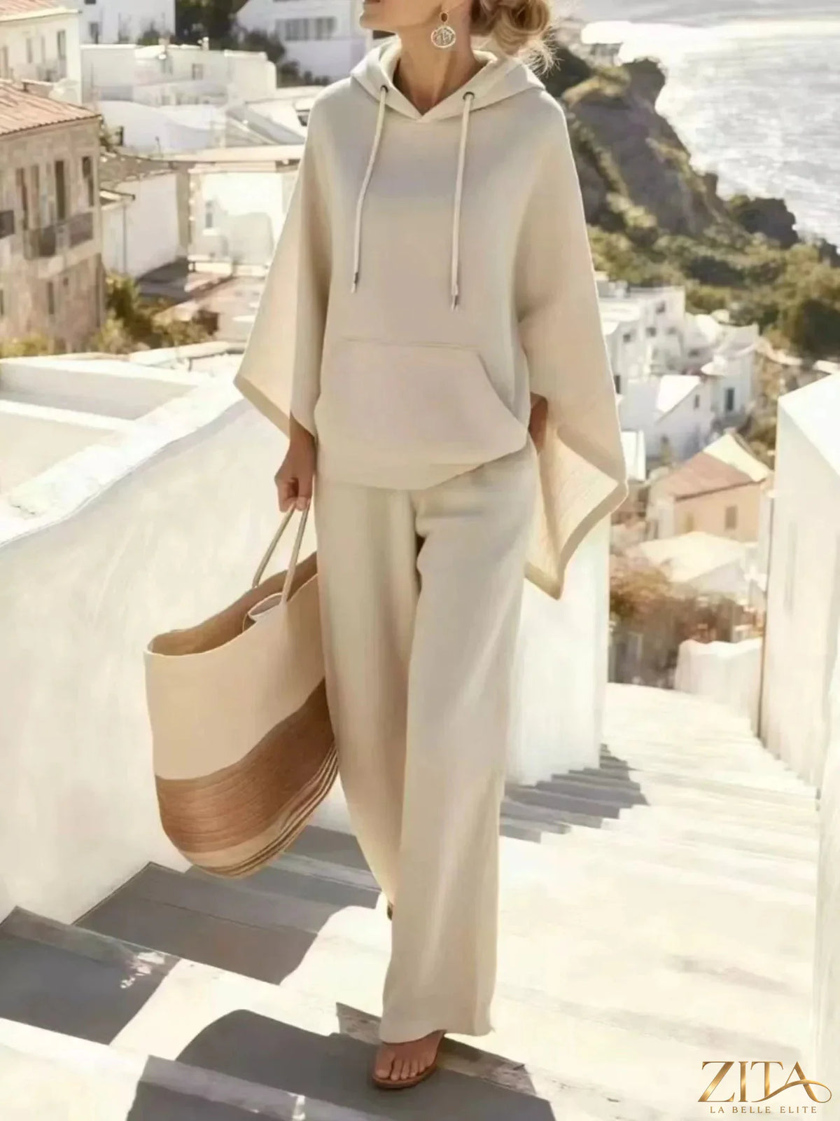 Zita La Belle Elite hooded poncho and wide-leg pants set in soft, flowing fabric worn by a model outdoors.
