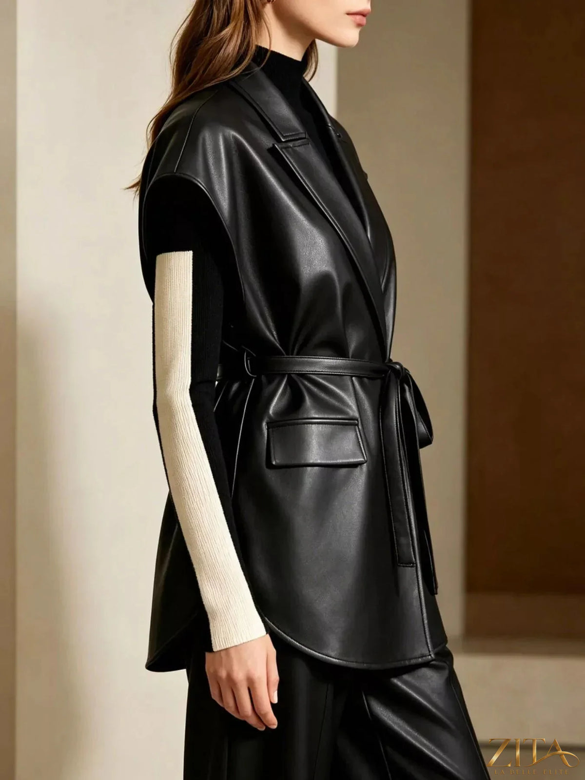 Zita La Belle Elite sleek faux leather belted vest coat displayed on a hanger, showcasing its smooth texture and stylish design.