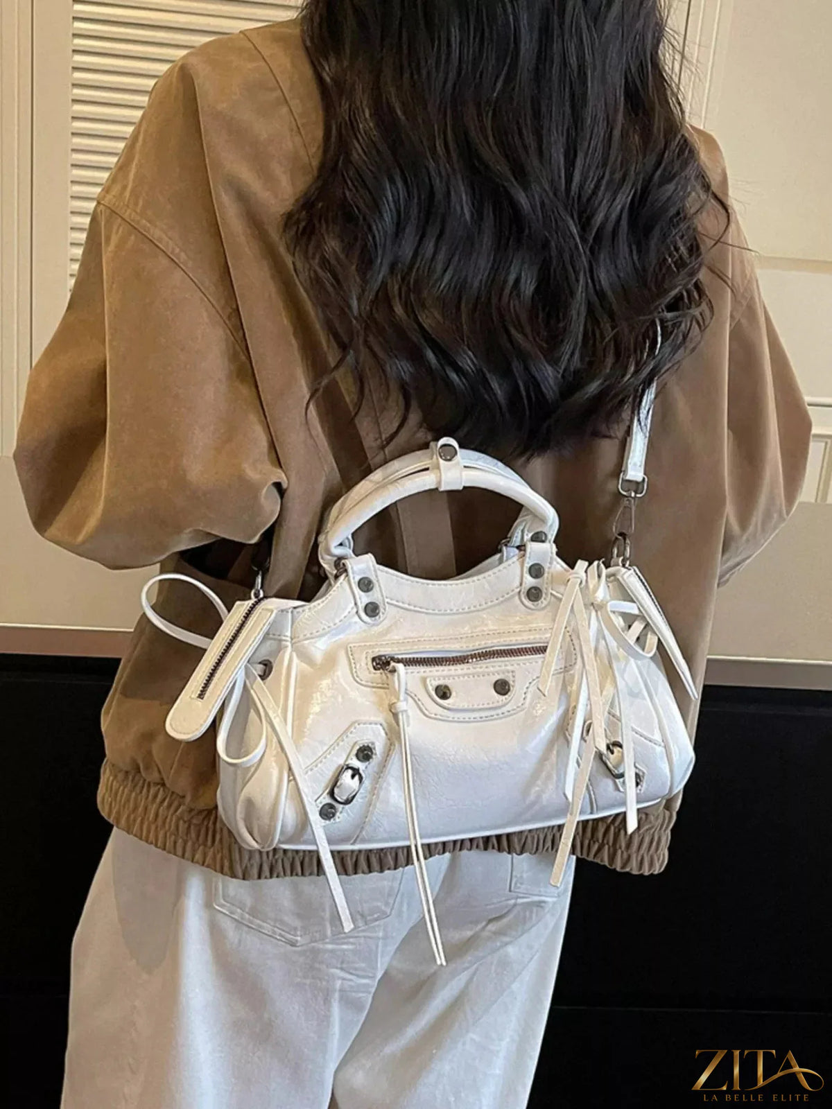 Leather tassel handbag with adjustable strap and gold accents, featuring a stylish and spacious design from Trendsi.