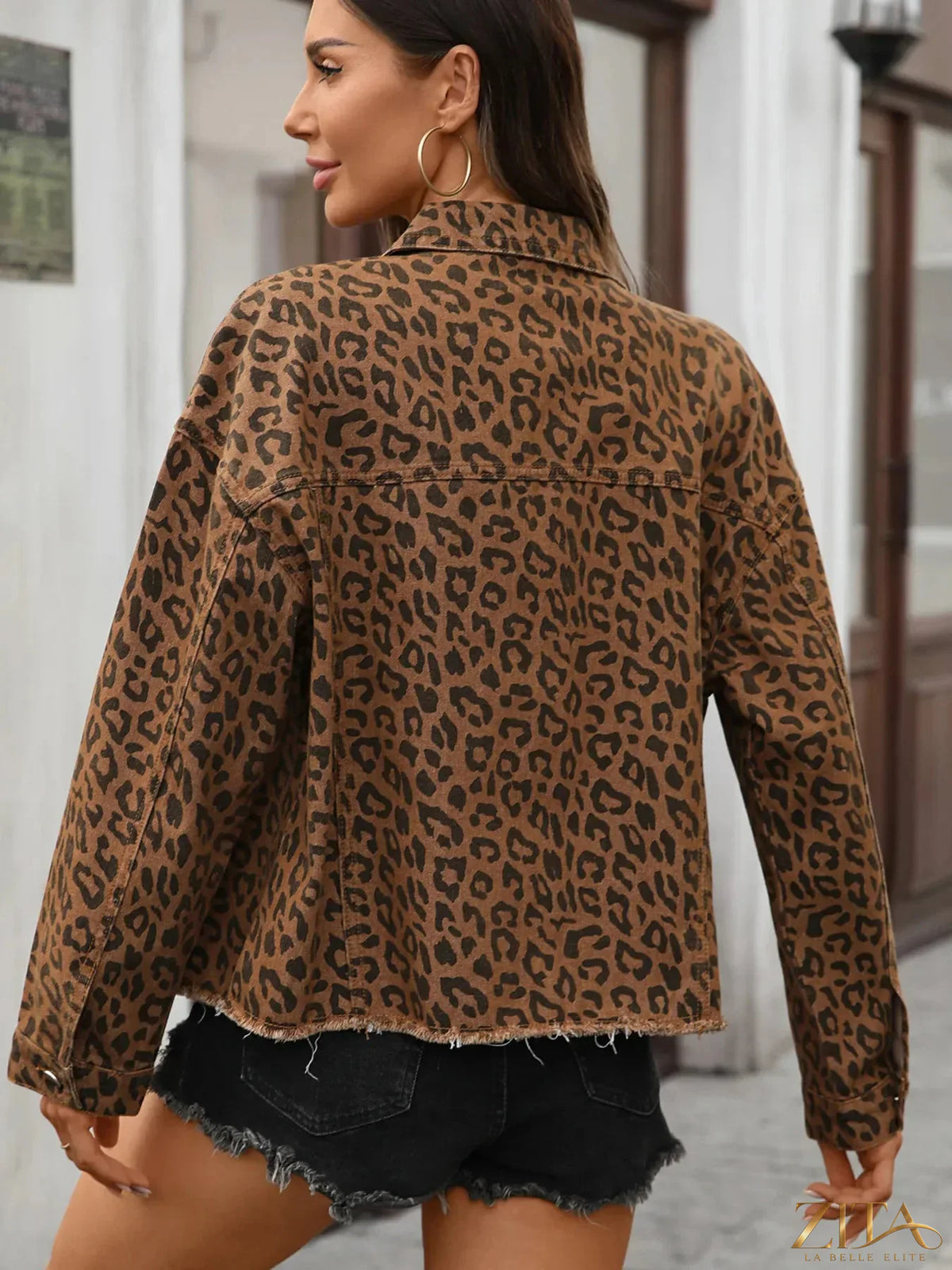 Zita La Belle Elite leopard print raw hem denim jacket hanging on a rack, showcasing its stylish animal print and casual fit.