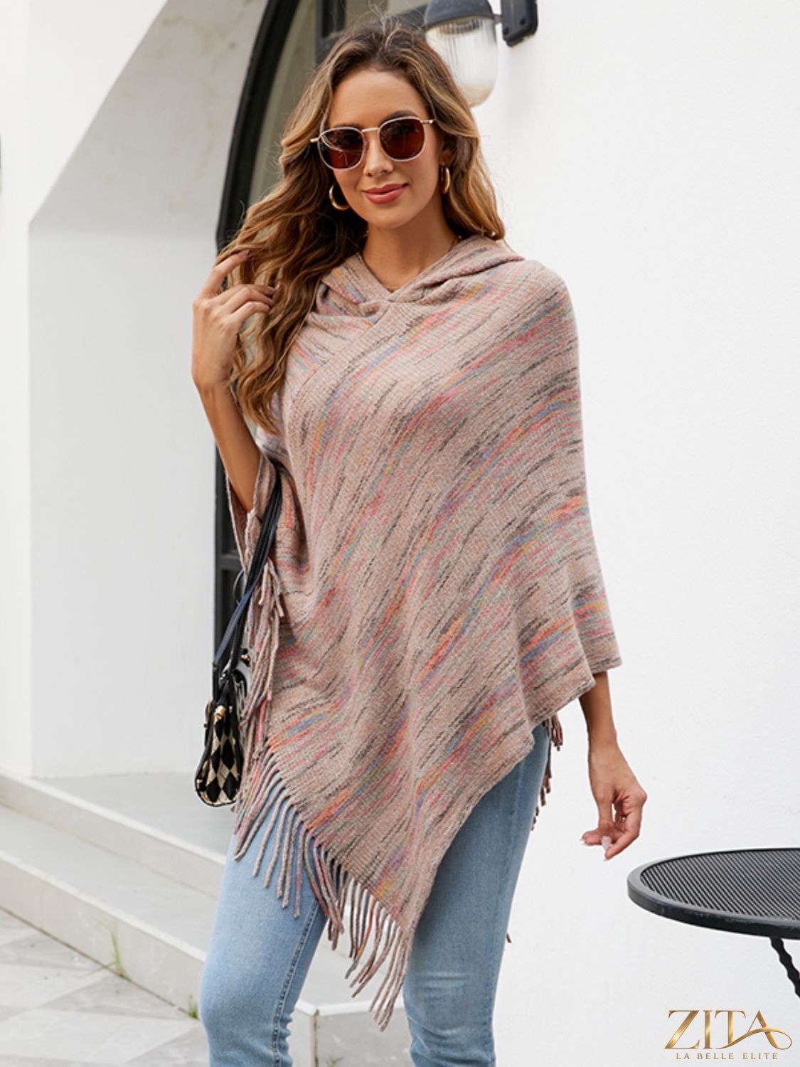 Zita La Belle Elite fringe hem hooded poncho in cozy fabric with tassel details, draped over a model in a neutral setting.