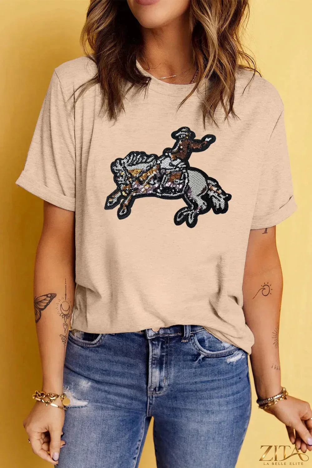 Sequin Rodeo graphic crewneck T-shirt from Trendsi featuring a colorful rodeo design on a casual crewneck tee.