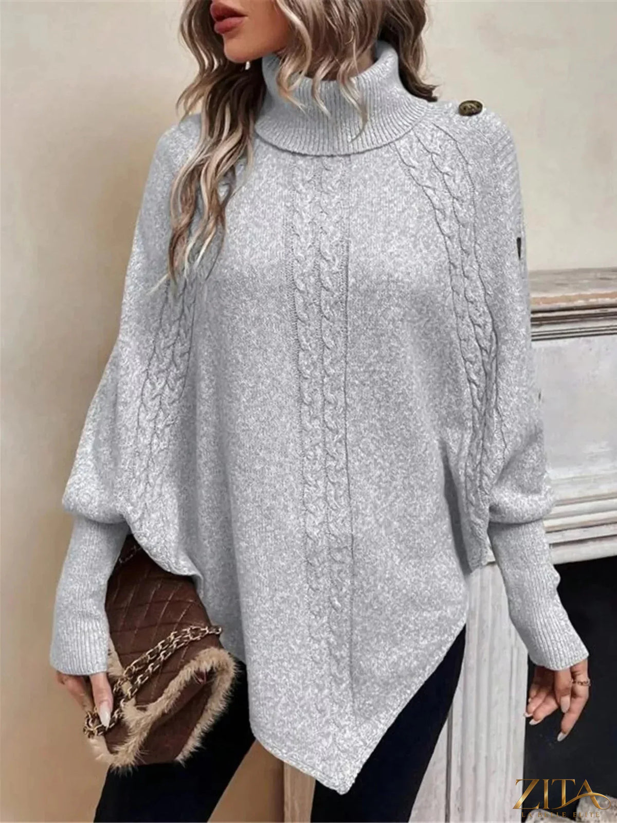 Cable knit turtleneck cape sweater by Trendsi, featuring a cozy, textured design with a high neckline and flowing cape silhouette.
