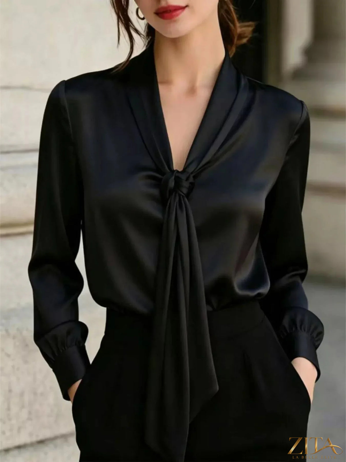 Zita La Belle Elite satin blouse with front tie detail, showcasing a smooth fabric and stylish neckline on a mannequin.