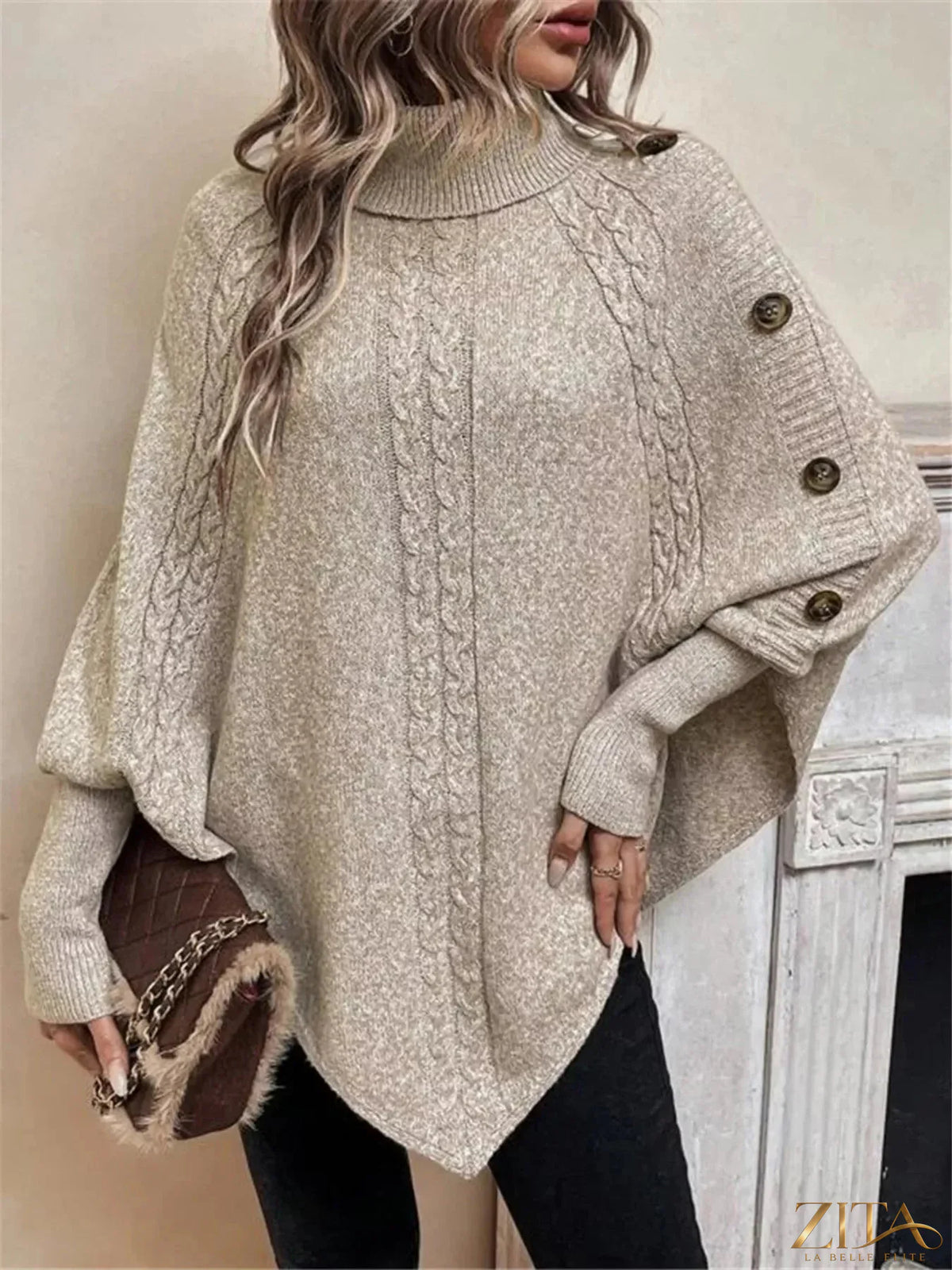 Cable knit turtleneck cape sweater by Trendsi, featuring a cozy, oversized design with a turtleneck collar and textured knit pattern.