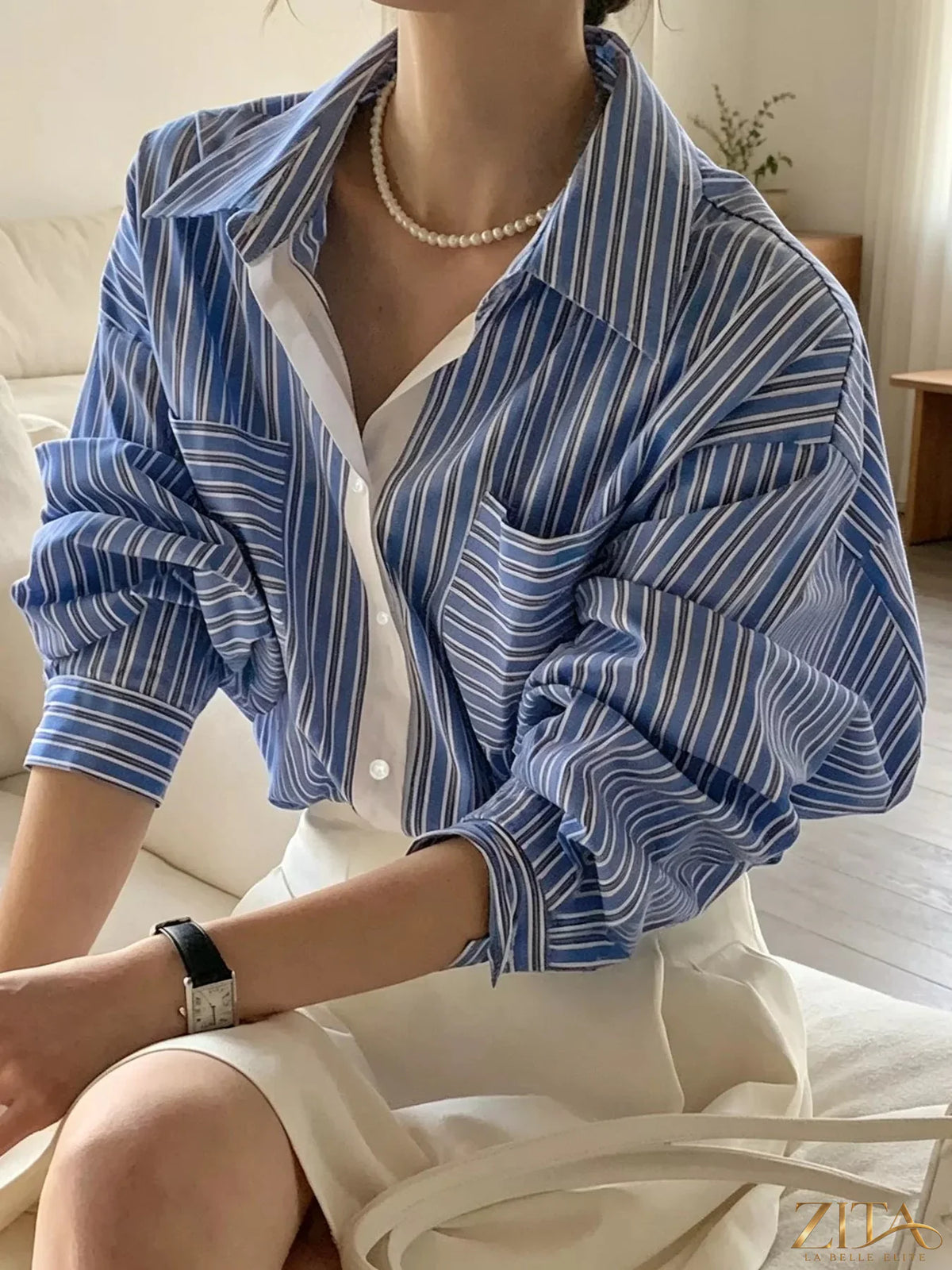 Zita La Belle Elite striped button-down shirt with blue and white vertical stripes, displayed on a hanger.