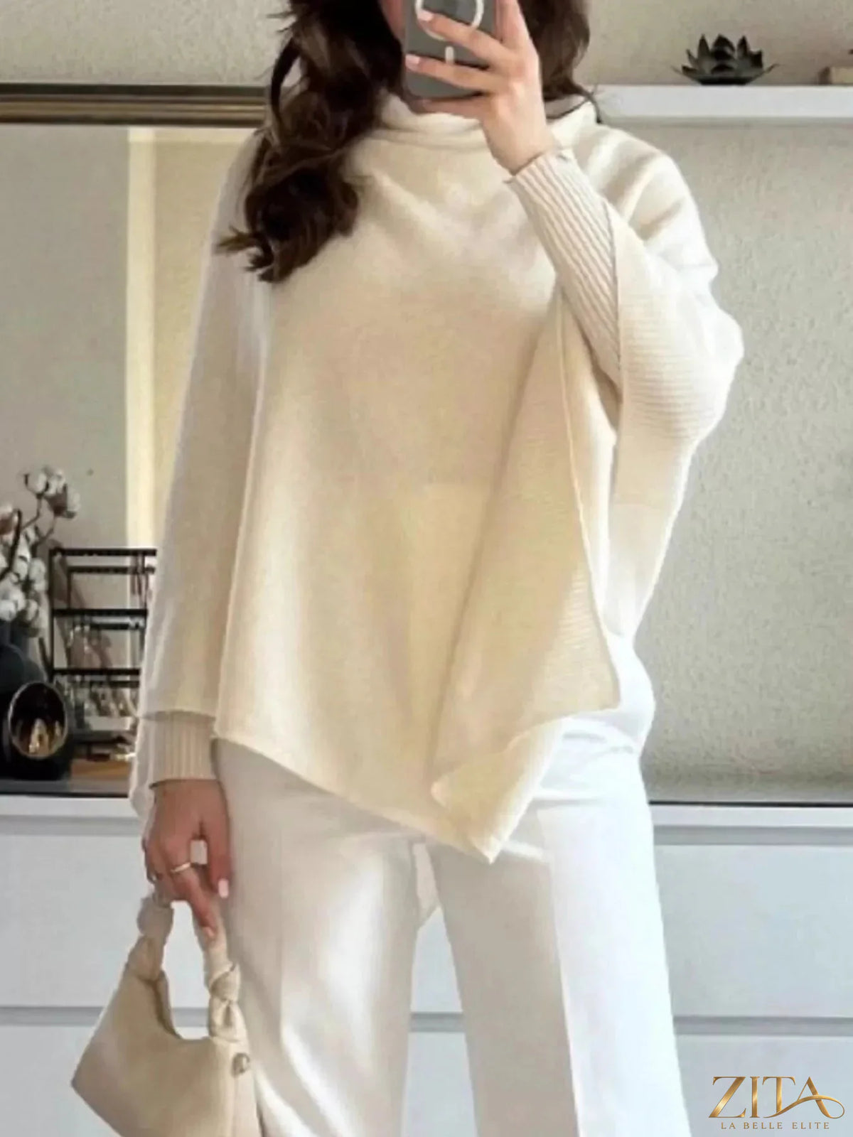 Loose knit turtleneck sweater poncho by Trendsi featuring a cozy, oversized design and warm, textured fabric.