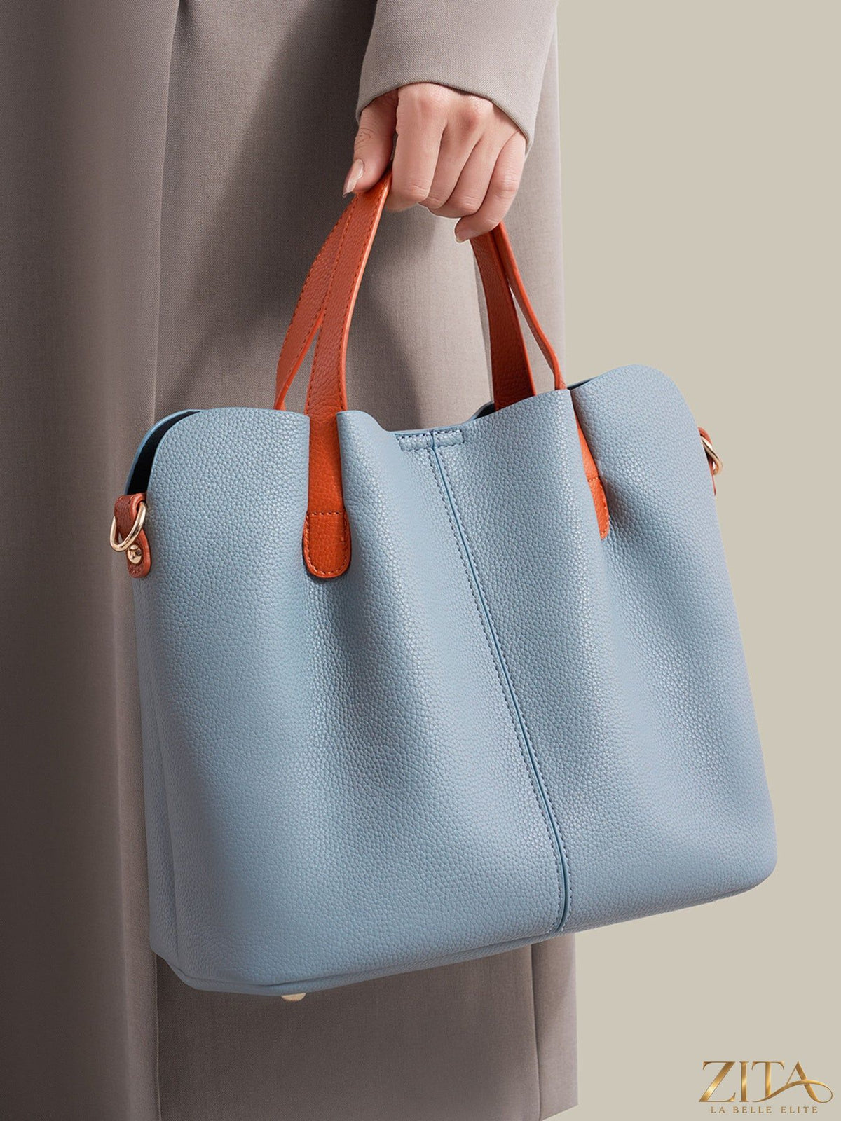 Leather contrast handle handbag with structured design and metal hardware, featuring a sleek and stylish look.