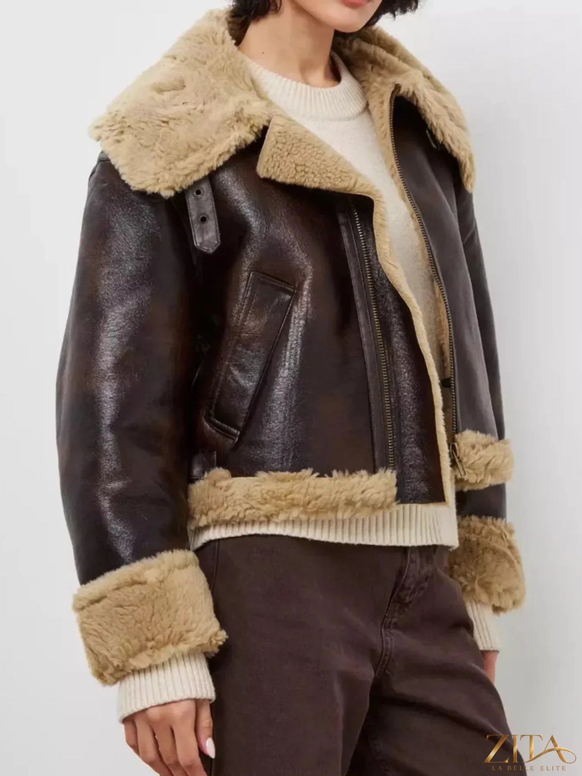 Vintage-inspired faux leather aviator jacket with plush shearling trim, featuring classic design and detailed stitching from Zita La Belle Elite.