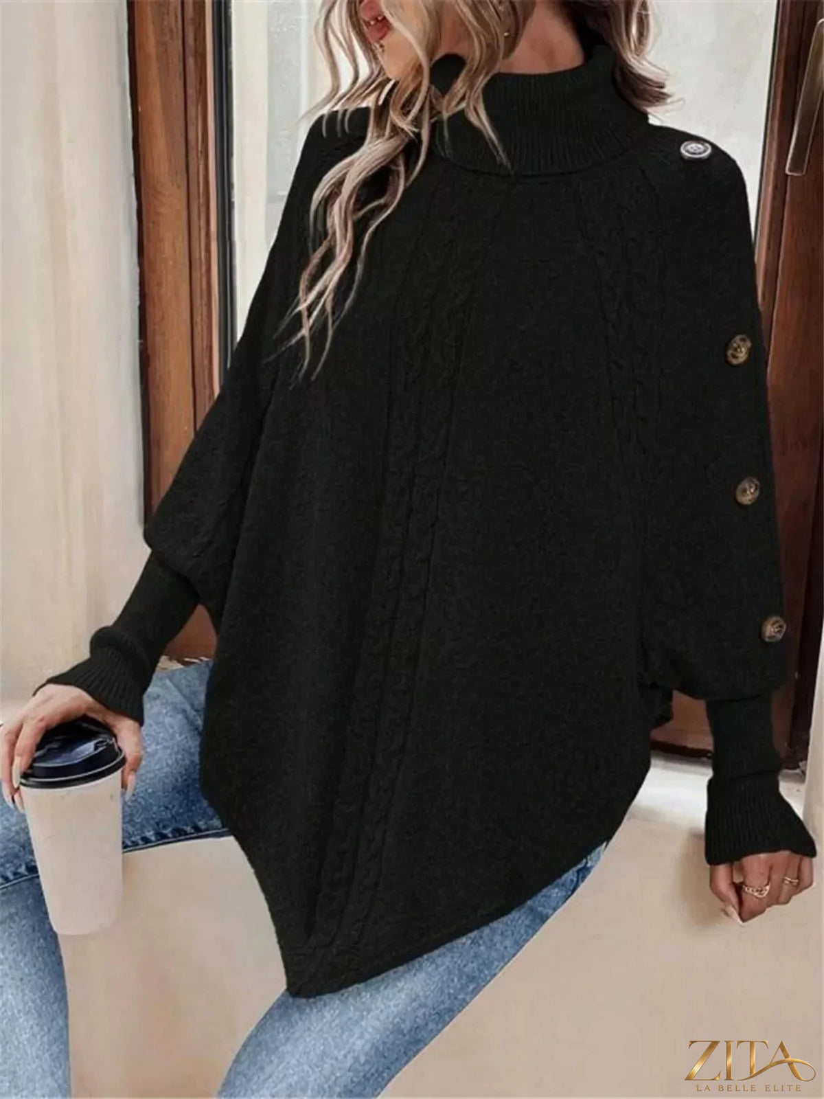 Cable knit turtleneck cape sweater by Trendsi, featuring a cozy, oversized design with a high turtleneck and textured knit pattern.