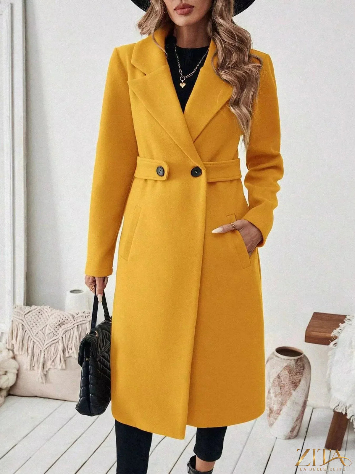 Zita La Belle Elite single-button longline coat in neutral fabric, shown hanging on a wooden hanger with a minimalist background.