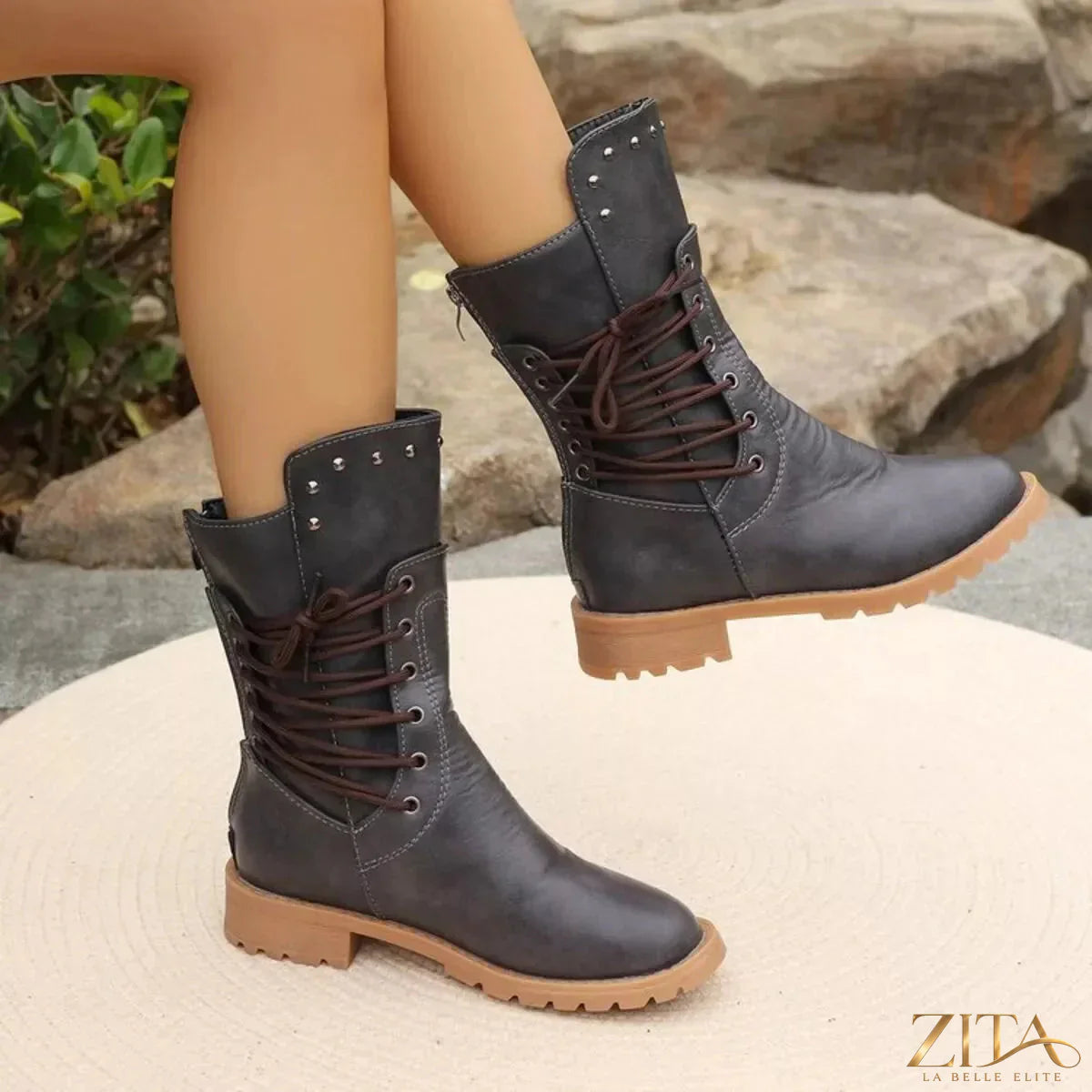 Black studded lace-up boots from Trendsi featuring chunky heels and silver hardware, styled with jeans.