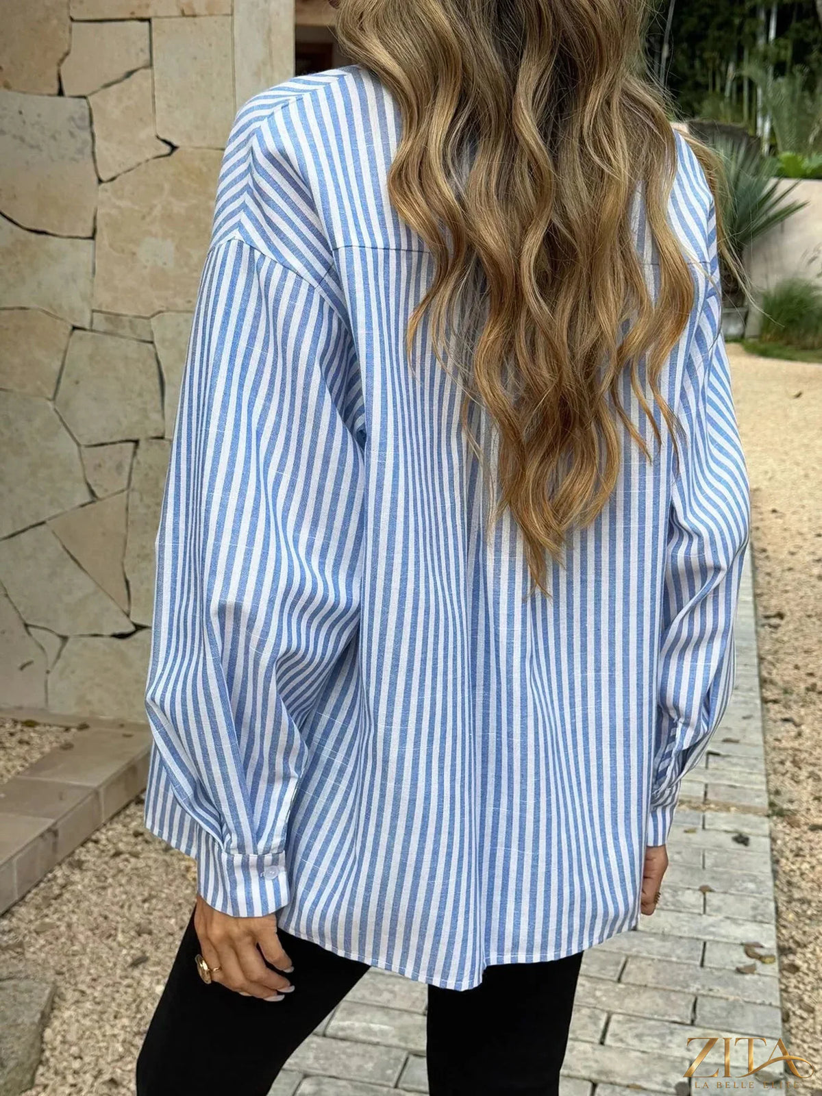 Zita La Belle Elite striped button-down shirt with blue and white vertical stripes, folded on a white background.