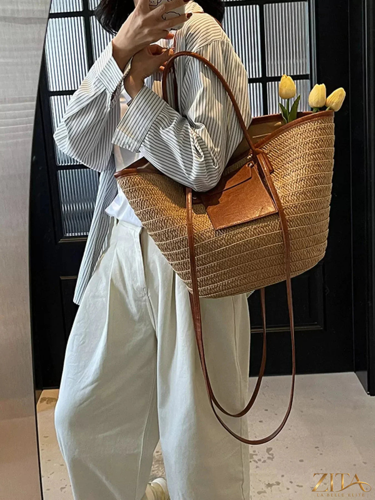 Woven straw tote bag by Zita La Belle Elite with leather handles, showing a spacious, natural-colored design perfect for summer outings.