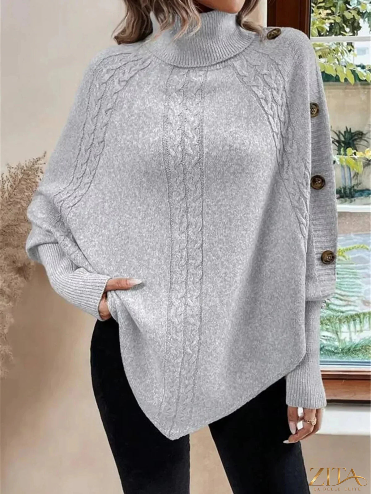 Cable knit turtleneck cape sweater by Trendsi, featuring a cozy, textured design with a high turtleneck and flowing cape silhouette.