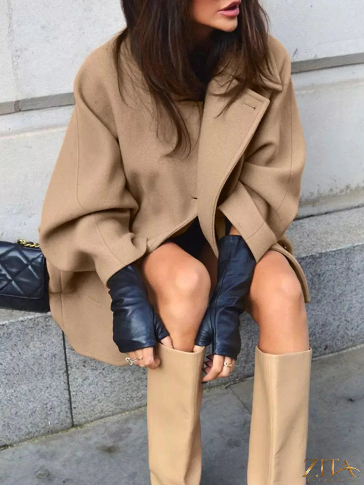 Zita La Belle Elite oversized lapel collar button-down coat hanging on a wooden rack, showcasing its classic design and neutral color