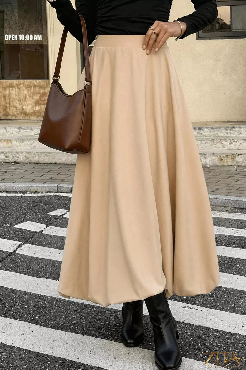 High-waisted A-line midi skirt from Trendsi showing a flowy, knee-length skirt with a fitted waist and smooth fabric.