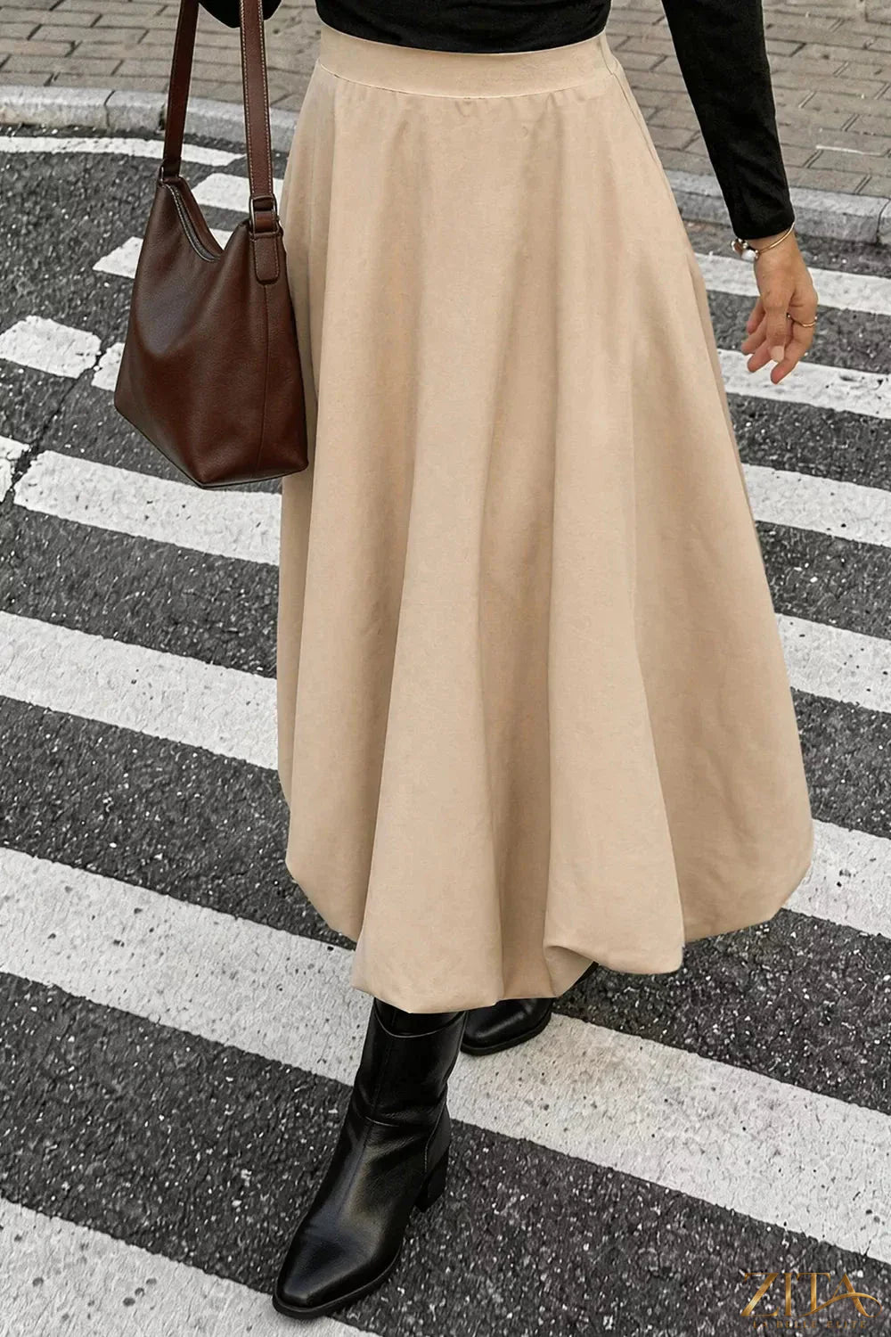 High-waisted A-line midi skirt from Trendsi featuring a flowy silhouette and classic design, shown on a neutral background.