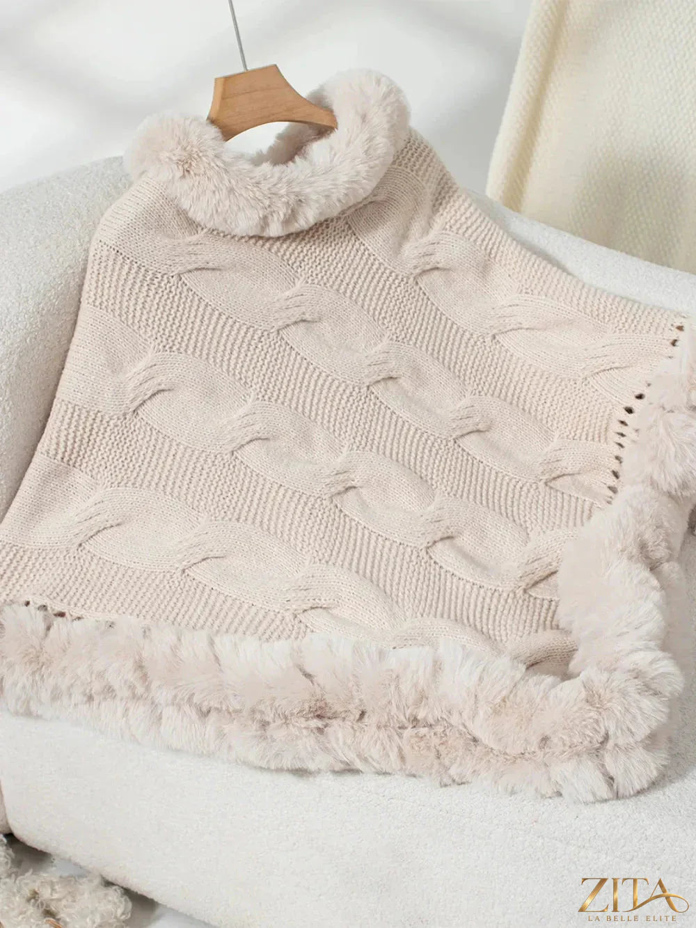 Fuzzy hem cable-knit poncho in neutral tones, showcasing cozy, textured fabric and relaxed fit from Trendsi.