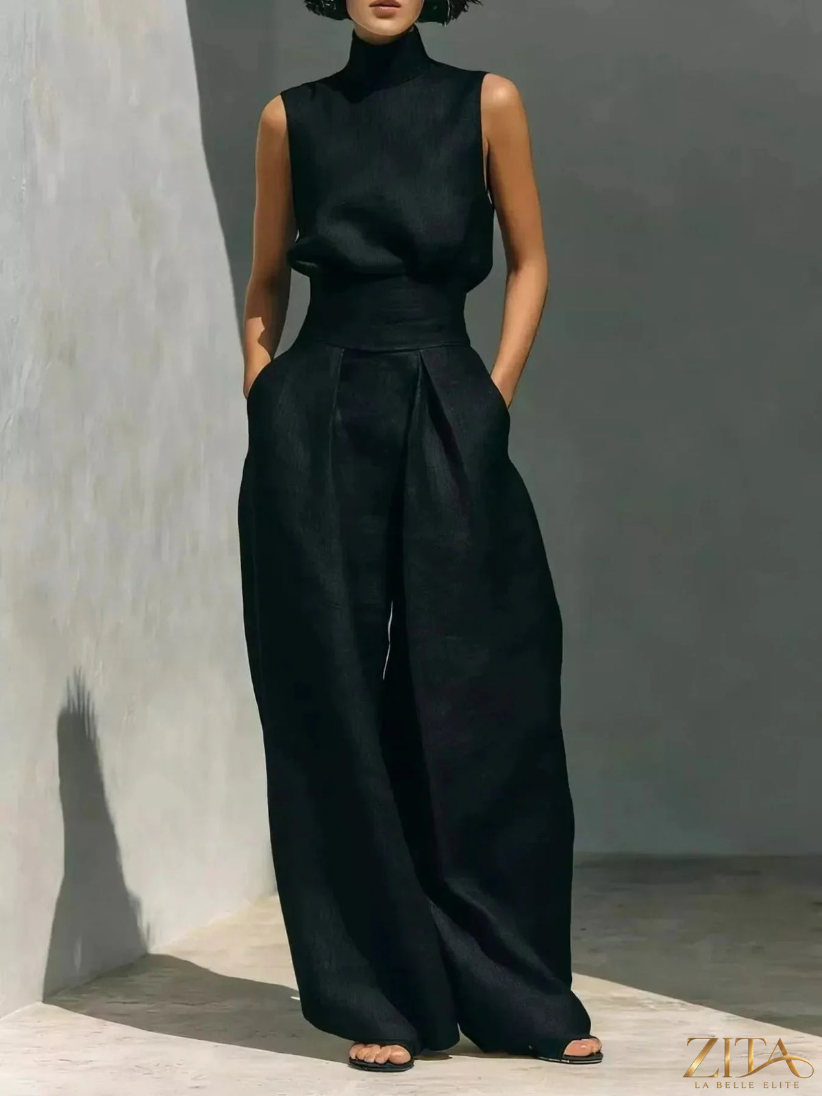 Sleeveless turtleneck top with wide-leg pants set by Trendsi, featuring a stylish, coordinated fashion look in neutral fabric.