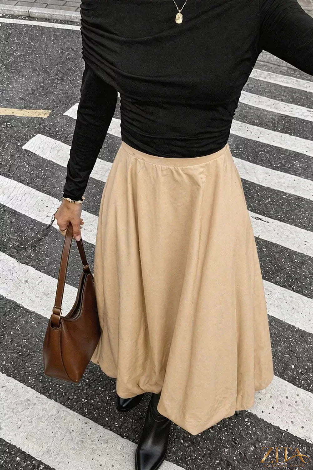 High-waisted A-line midi skirt by Trendsi, featuring a flowy silhouette and midi length, shown in a neutral color.