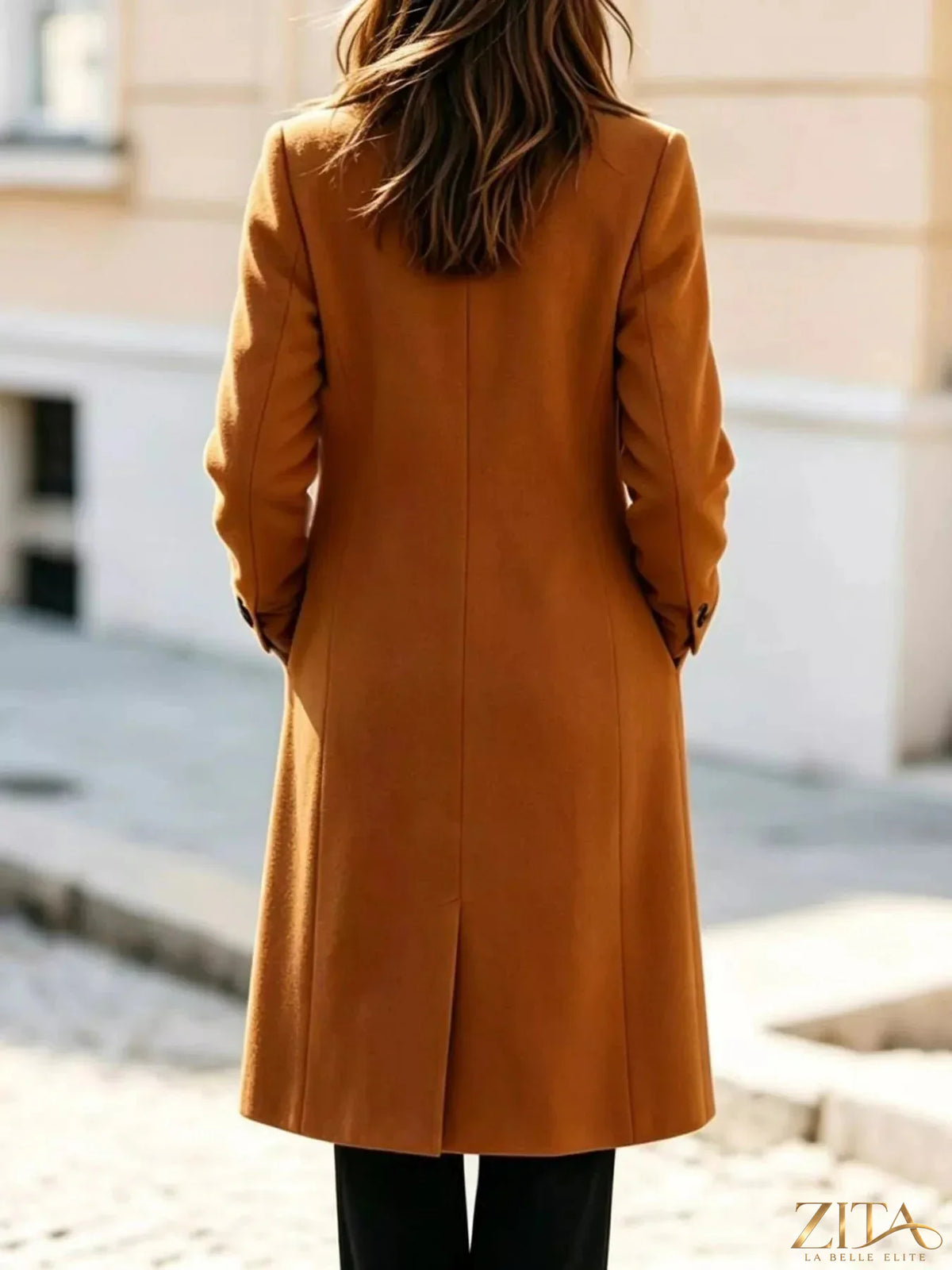 Zita La Belle Elite double-breasted coat with lapel collar, tailored silhouette, in dark wool fabric, displayed on a hanger.