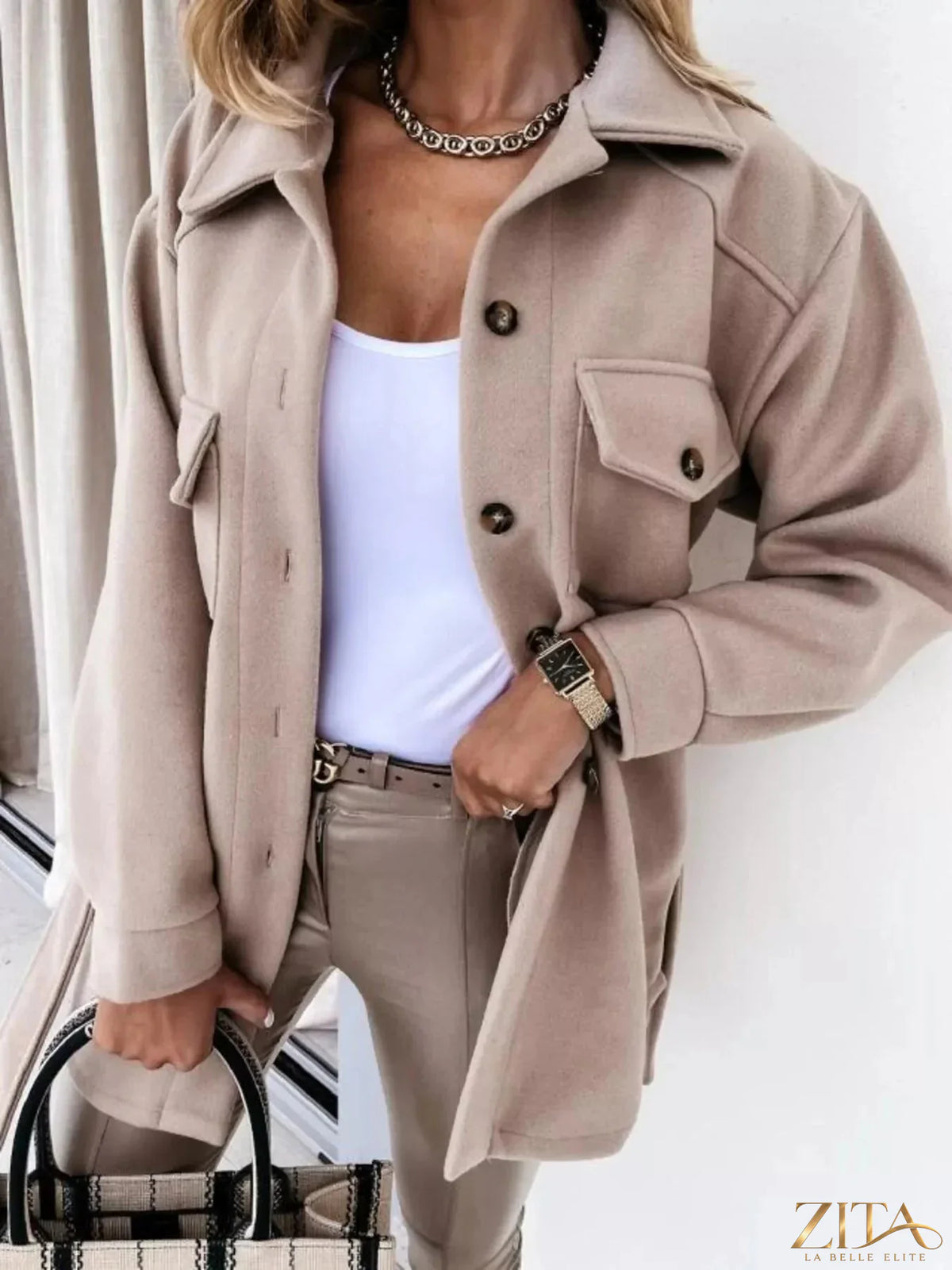 Zita La Belle Elite button-down tie waist coat hanging on a rack, stylish outerwear with a classic collar and waist tie detail.