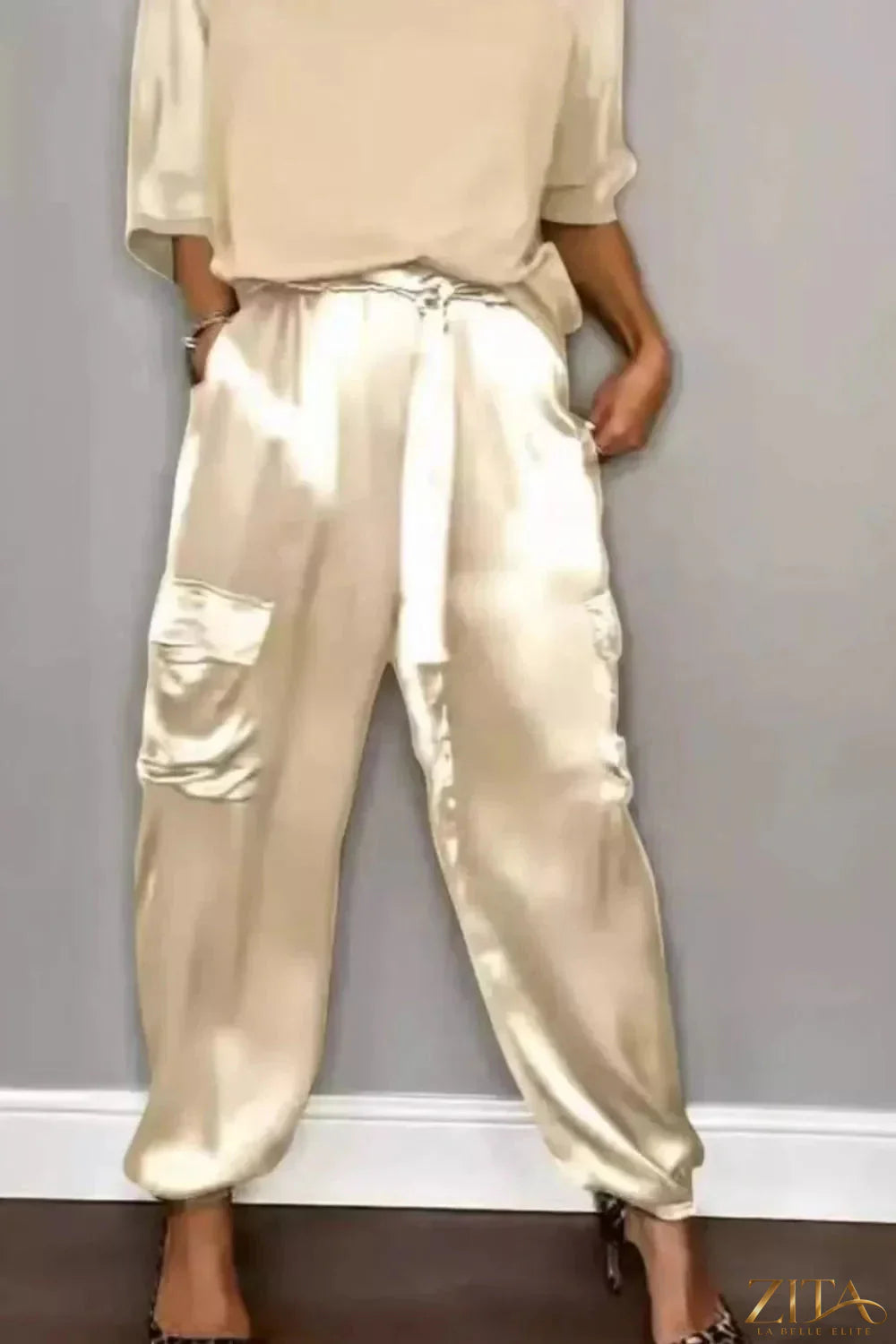 Satin round neck top and pants set in a sleek, shiny fabric, styled for a modern, elegant look.