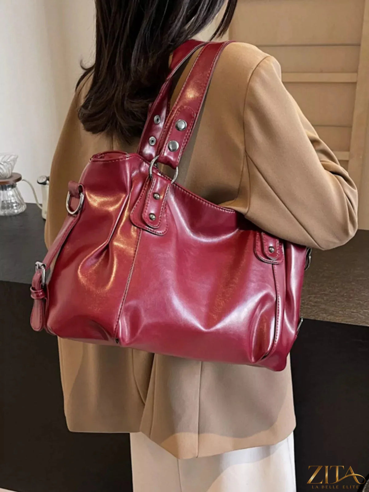 Vintage style leather handbag with adjustable strap, brass hardware, and classic design, perfect for casual or formal occasions.