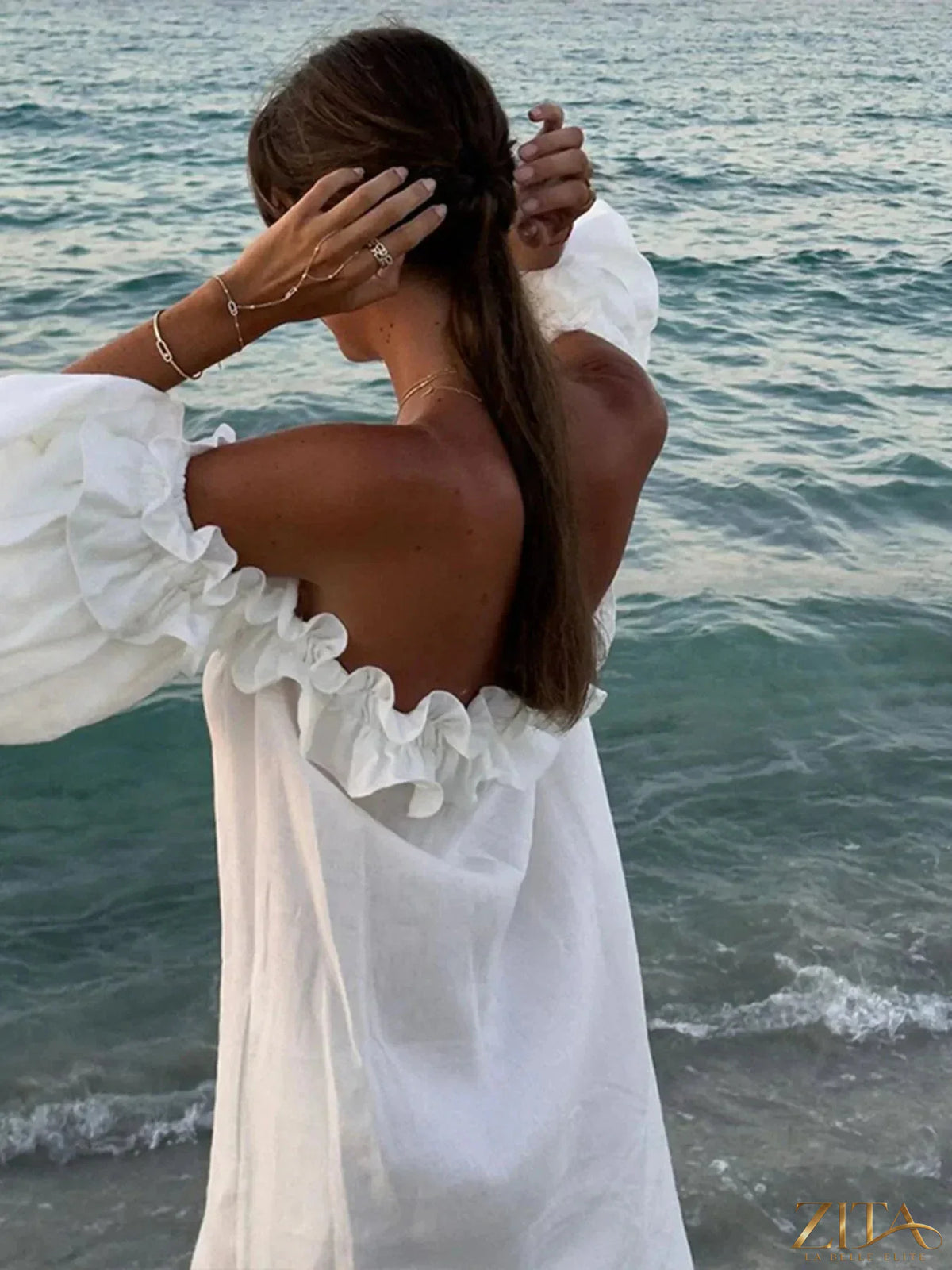 Zita La Belle Elite off-shoulder dress with side slit, flowing fabric, and elegant design perfect for summer or evening wear.