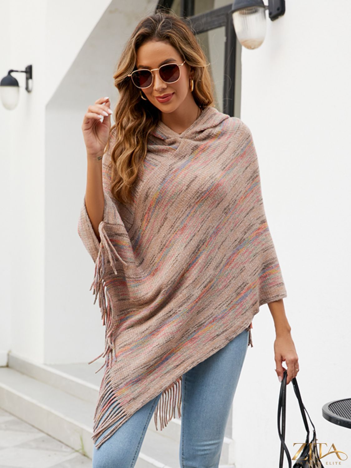 Zita La Belle Elite fringe hem hooded poncho in cozy fabric with tassel details, draped on a mannequin.