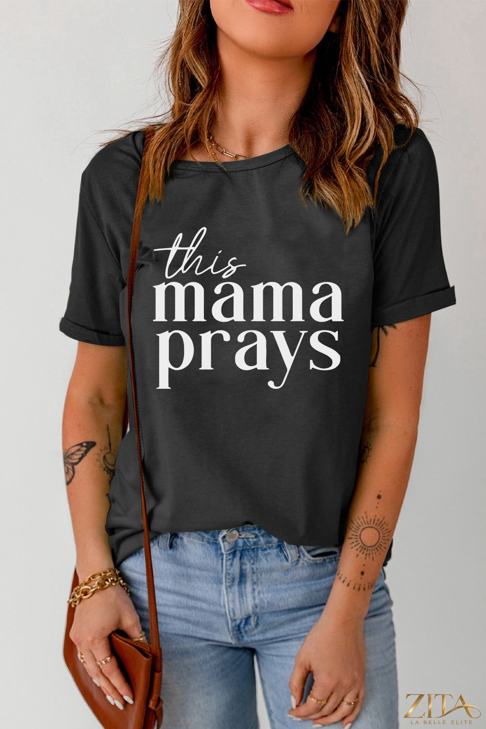 Black "This Mama Prays" graphic T-shirt by Trendsi, featuring bold white text on a casual crew neck tee.