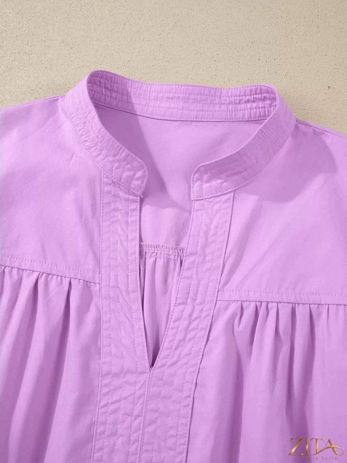 Zita La Belle Elite notched puff sleeve blouse with ruffled details and lightweight fabric on a white background.