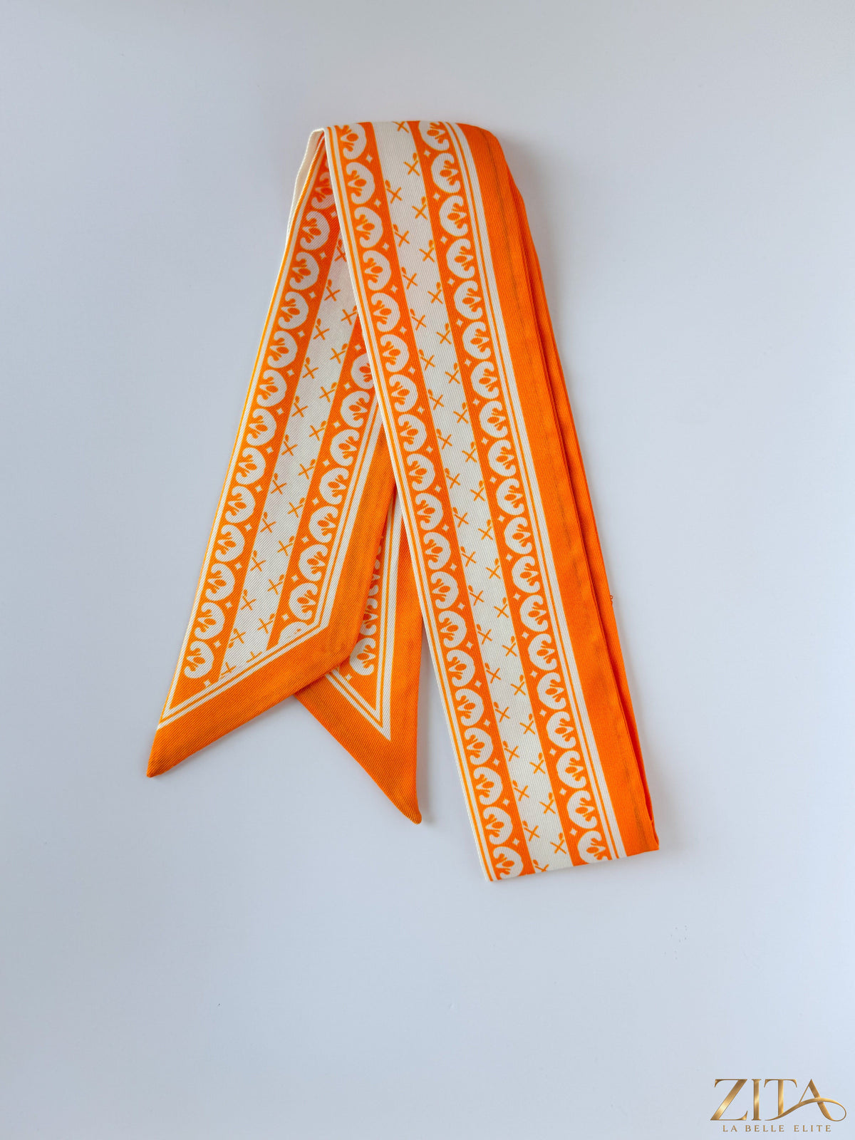 Orange and white ribbon twilly by Zita La Belle Elite featuring a stylish, lightweight silk design with a vibrant pattern.