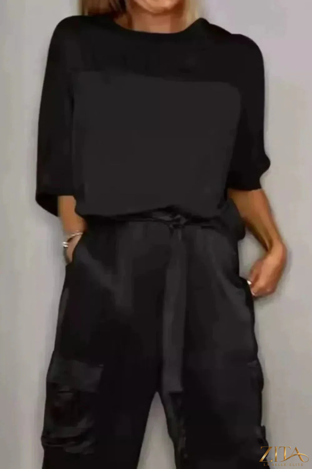 Satin round neck top and matching pants set in a smooth, shiny fabric, featuring a relaxed fit and elegant style.