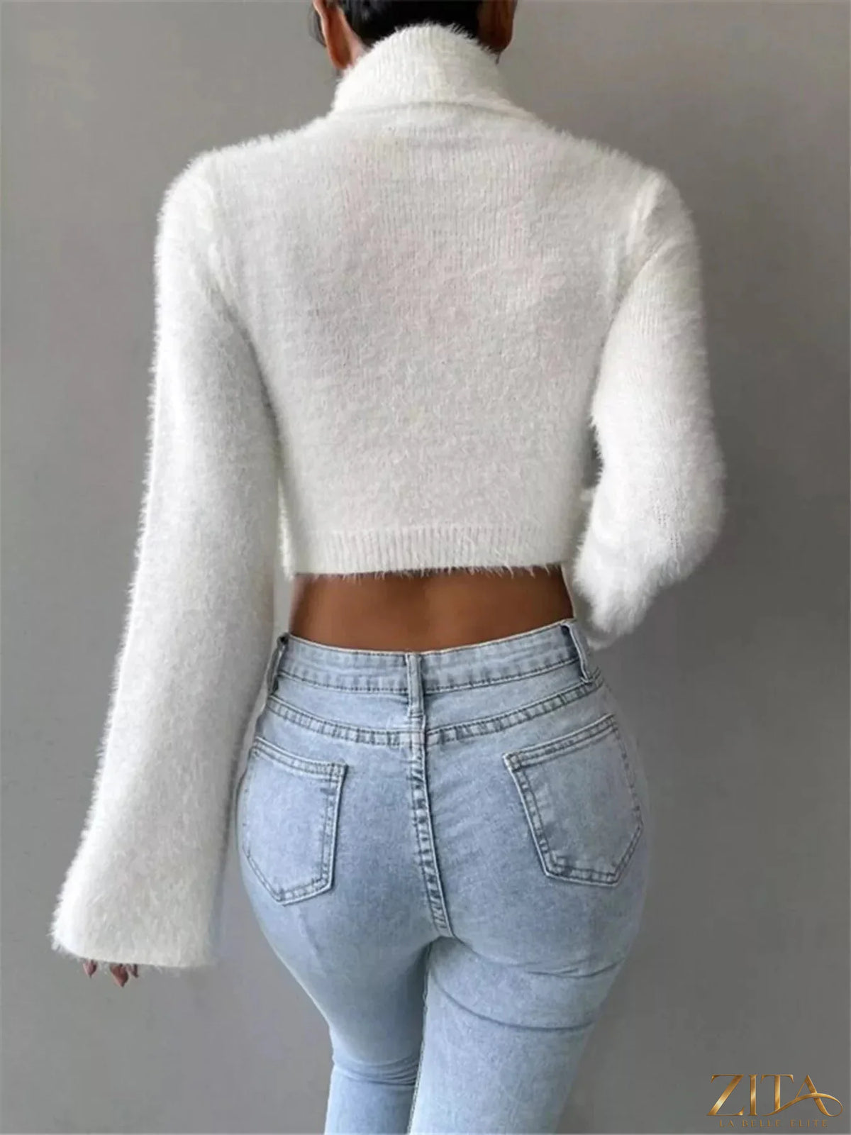Cream-colored turtleneck flare sleeve sweater by Trendsi, featuring a fitted bodice and dramatic flare sleeves.